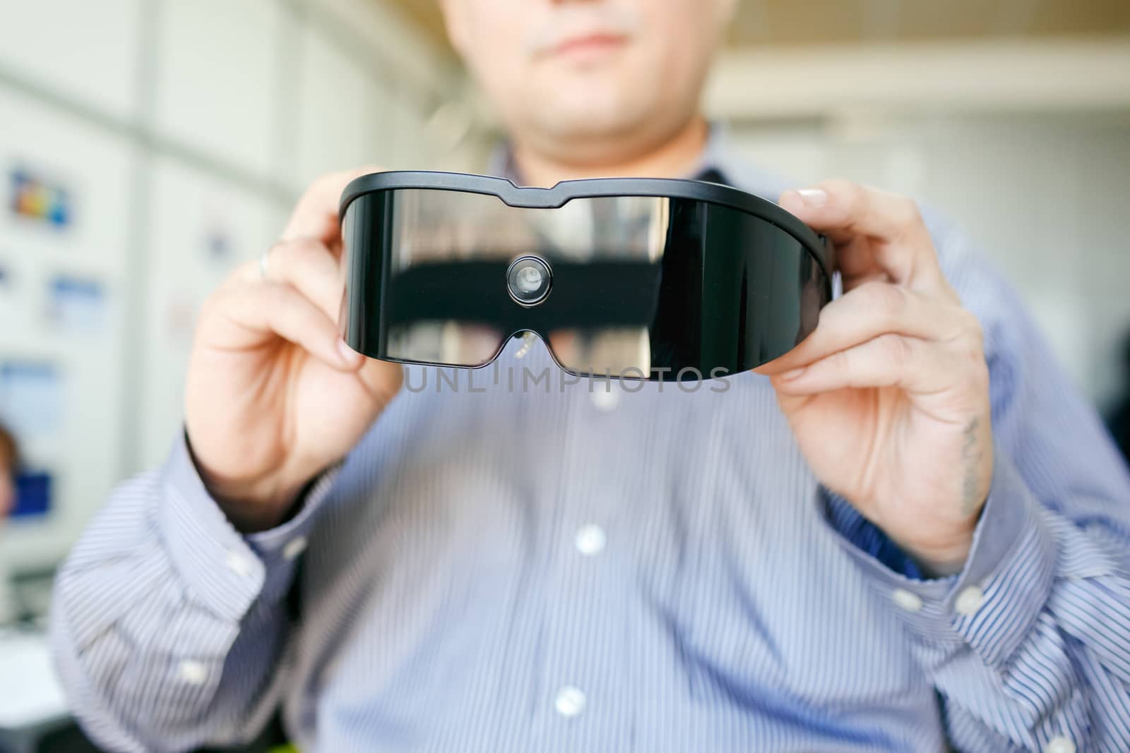 Virtual reality headset closeup in man's hands. by Maynagashev