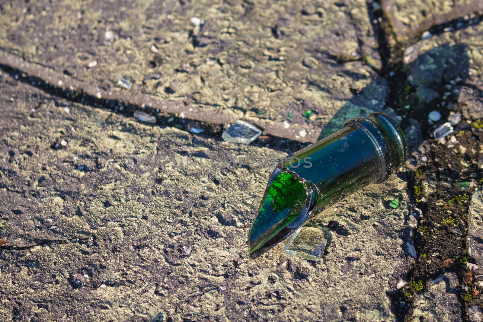 Broken bottle made of green glass as a symbol of vandalism and danger.