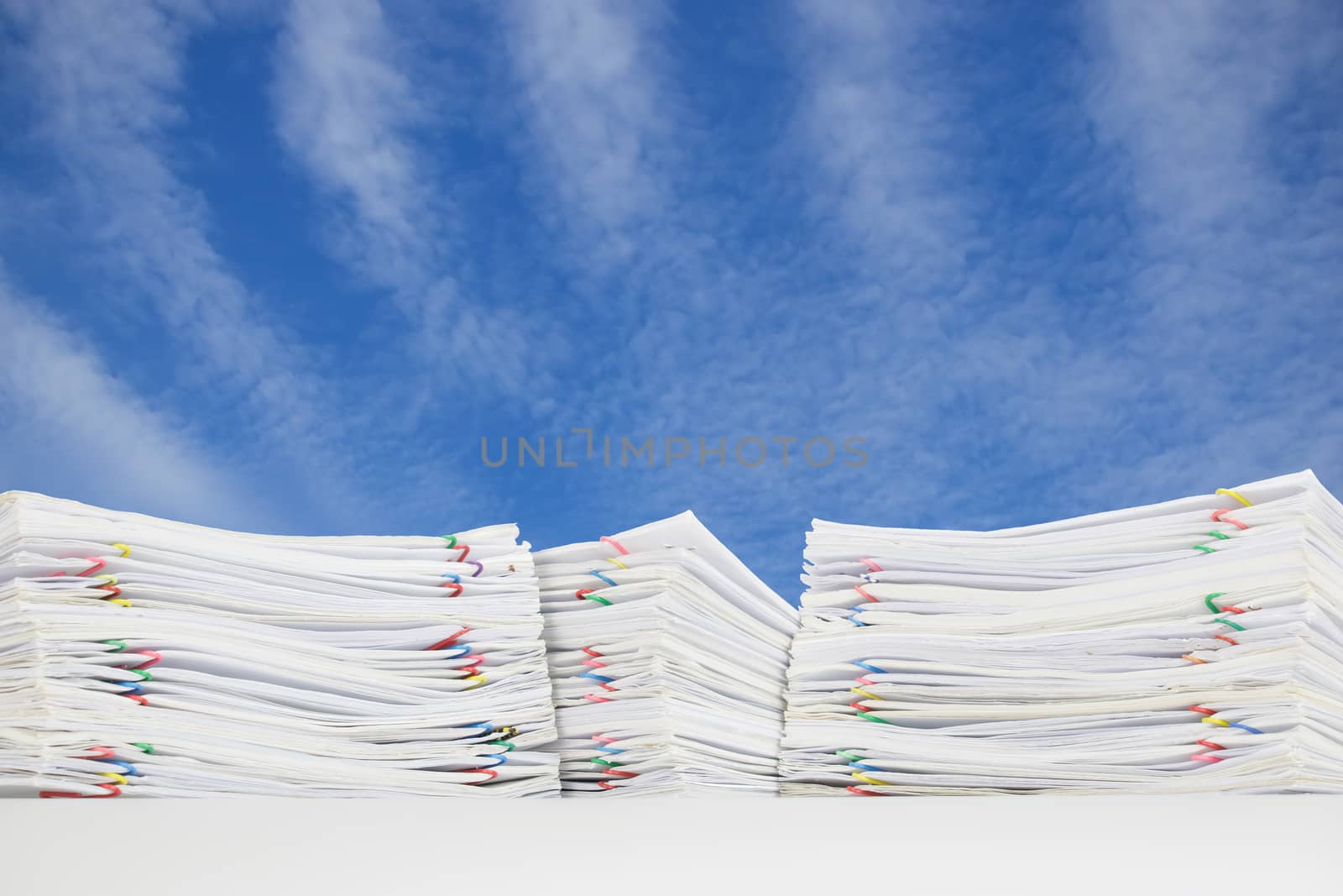 Overload of paperwork on blue sky with white cloud by eaglesky