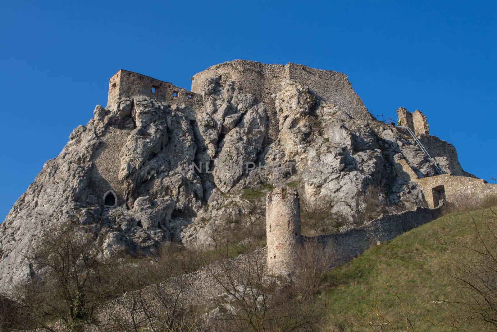 Rocky hill on the border of Slovakia and Austria, above river Danube. Former fortress. View on the ruins of the castle on the top of the hill. Blue sky.