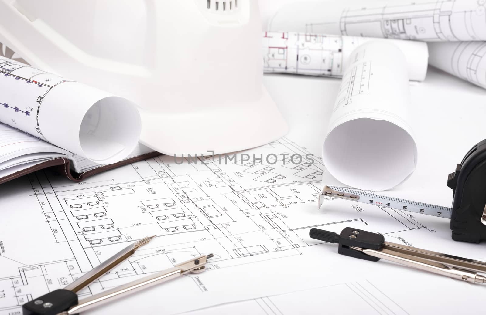Architecture plan and rolls of blueprints with meter and helmet. Building concept
