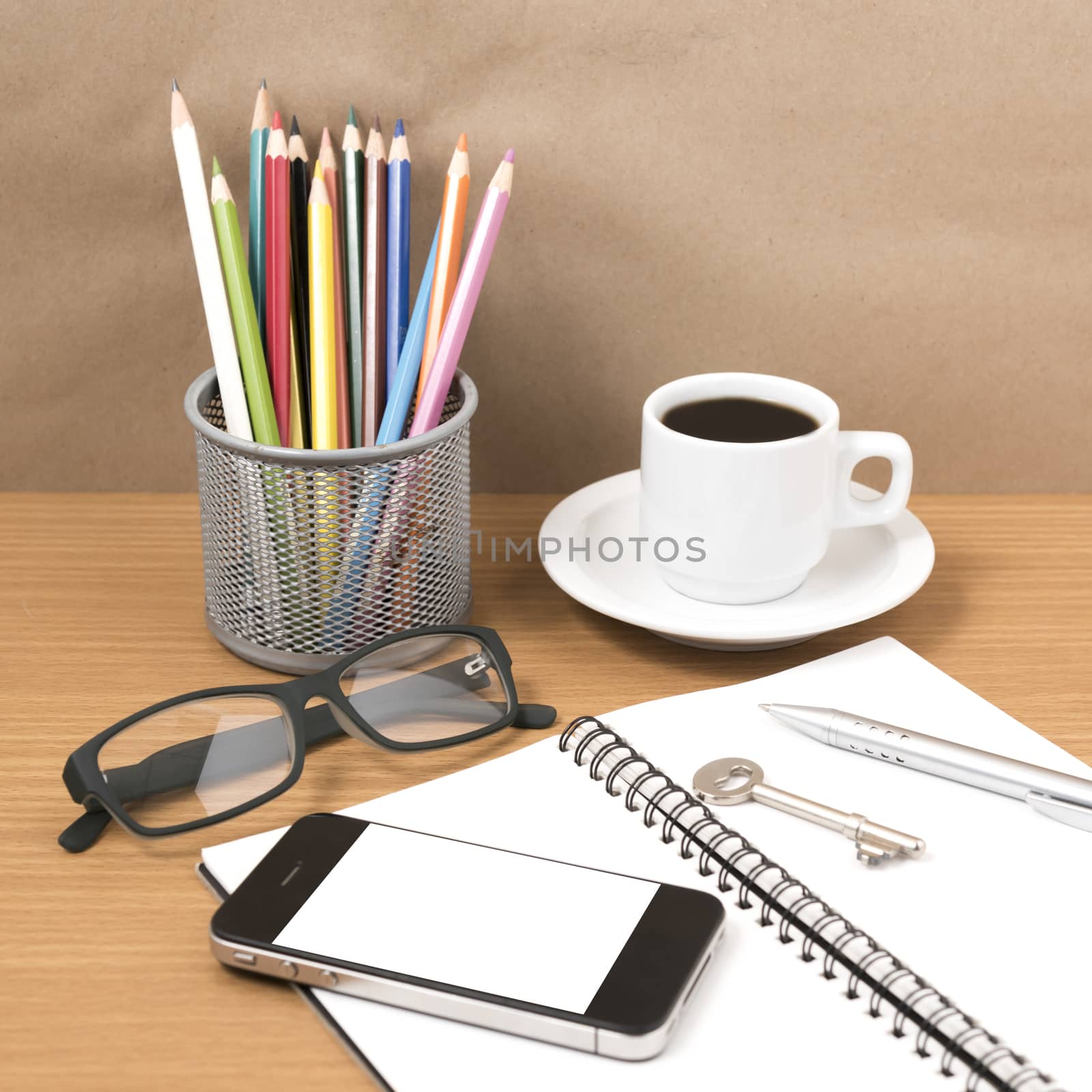 office desk : coffee and phone with key,eyeglasses,notepad,pencil box