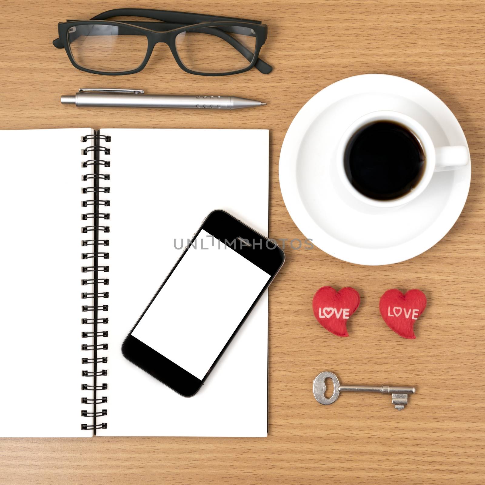 office desk : coffee and phone with key,eyeglasses,notepad,heart on wood background