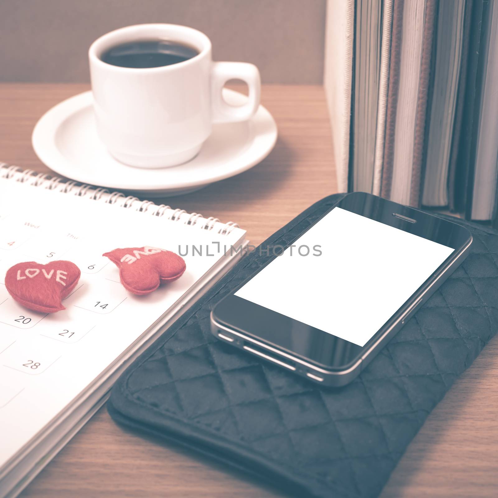 office desk : coffee with phone,wallet,calendar,heart,stack of book on wood background vintage style