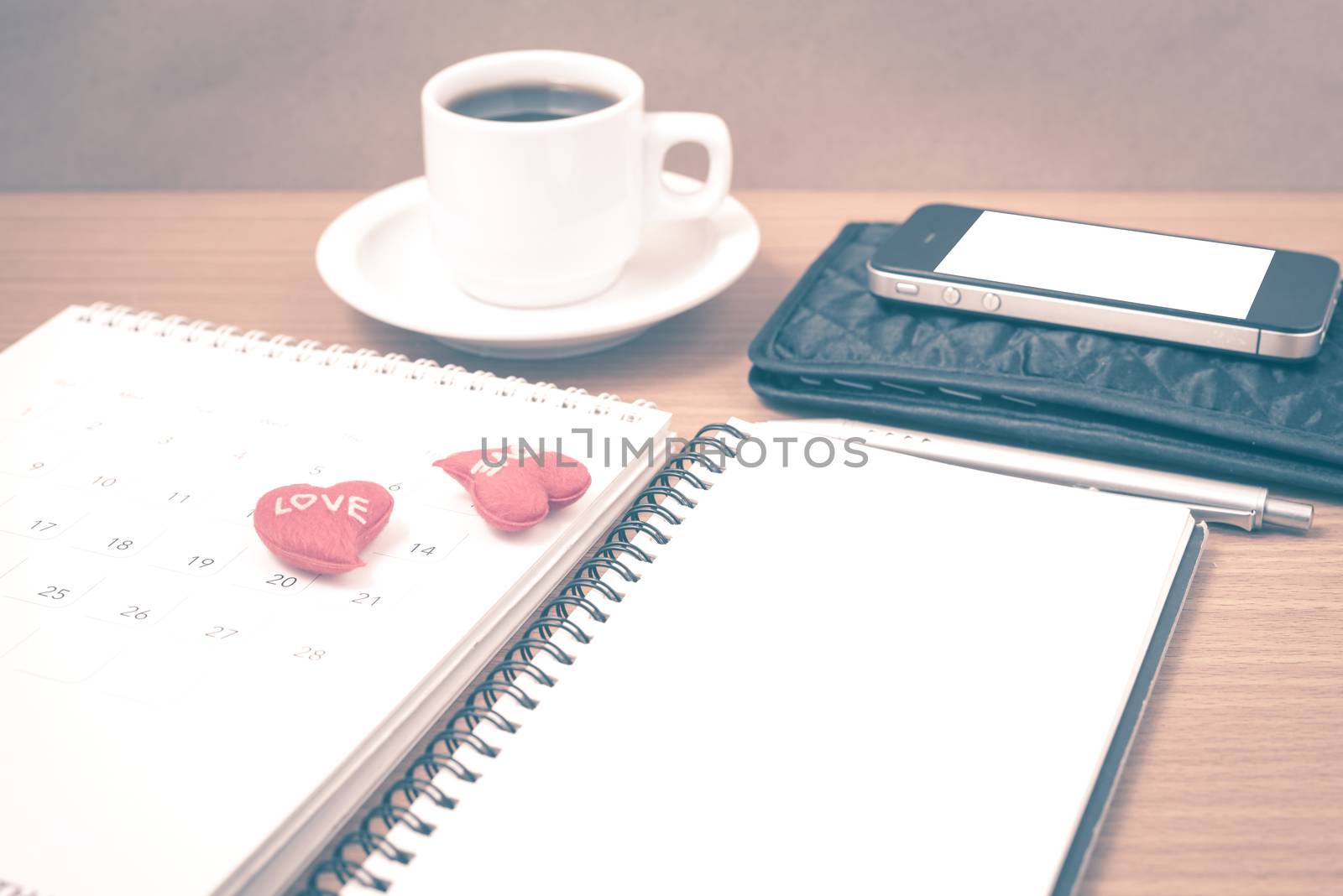 office desk : coffee with phone,wallet,calendar,heart,notepad on wood background vintage style