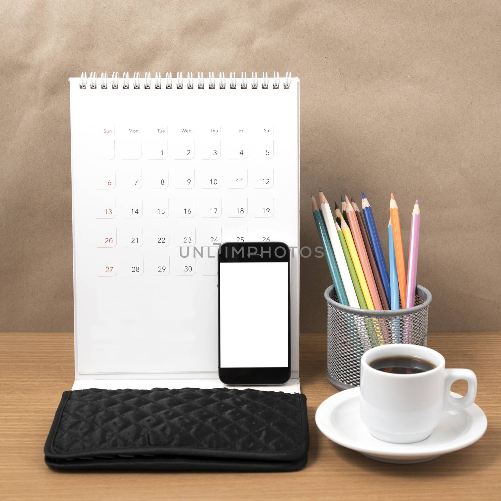 office desk : coffee with phone,calendar,wallet,color pencil on wood background