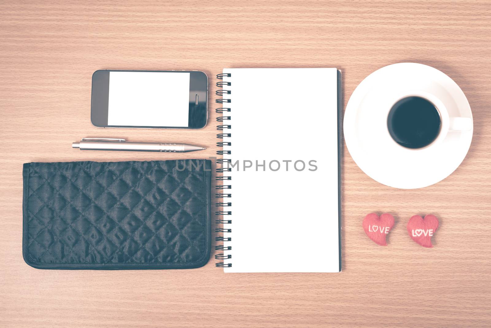 working table : coffee with phone,notepad,wallet and red heart on wood background vintage style