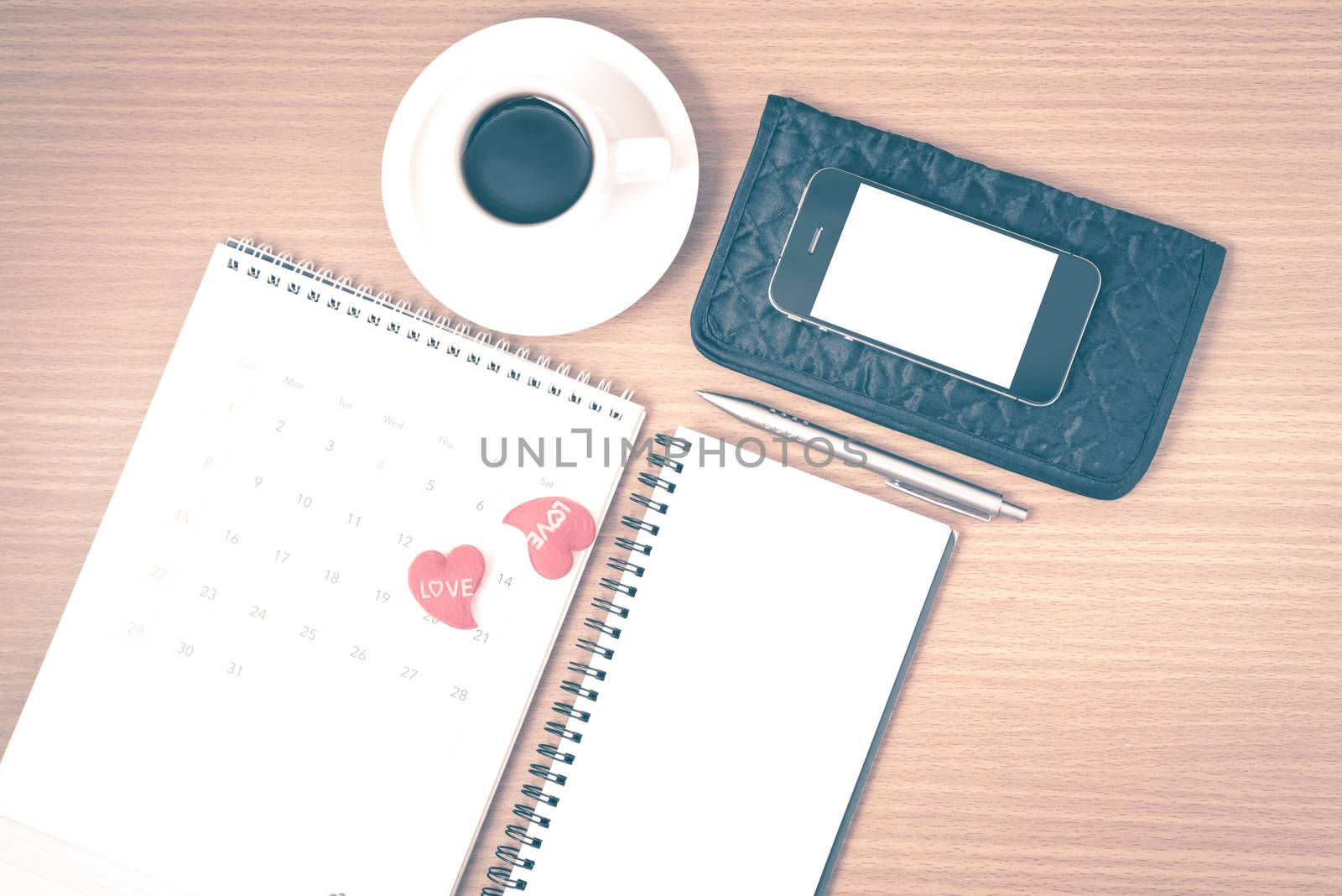 office desk : coffee with phone,wallet,calendar,heart,notepad on wood background vintage style