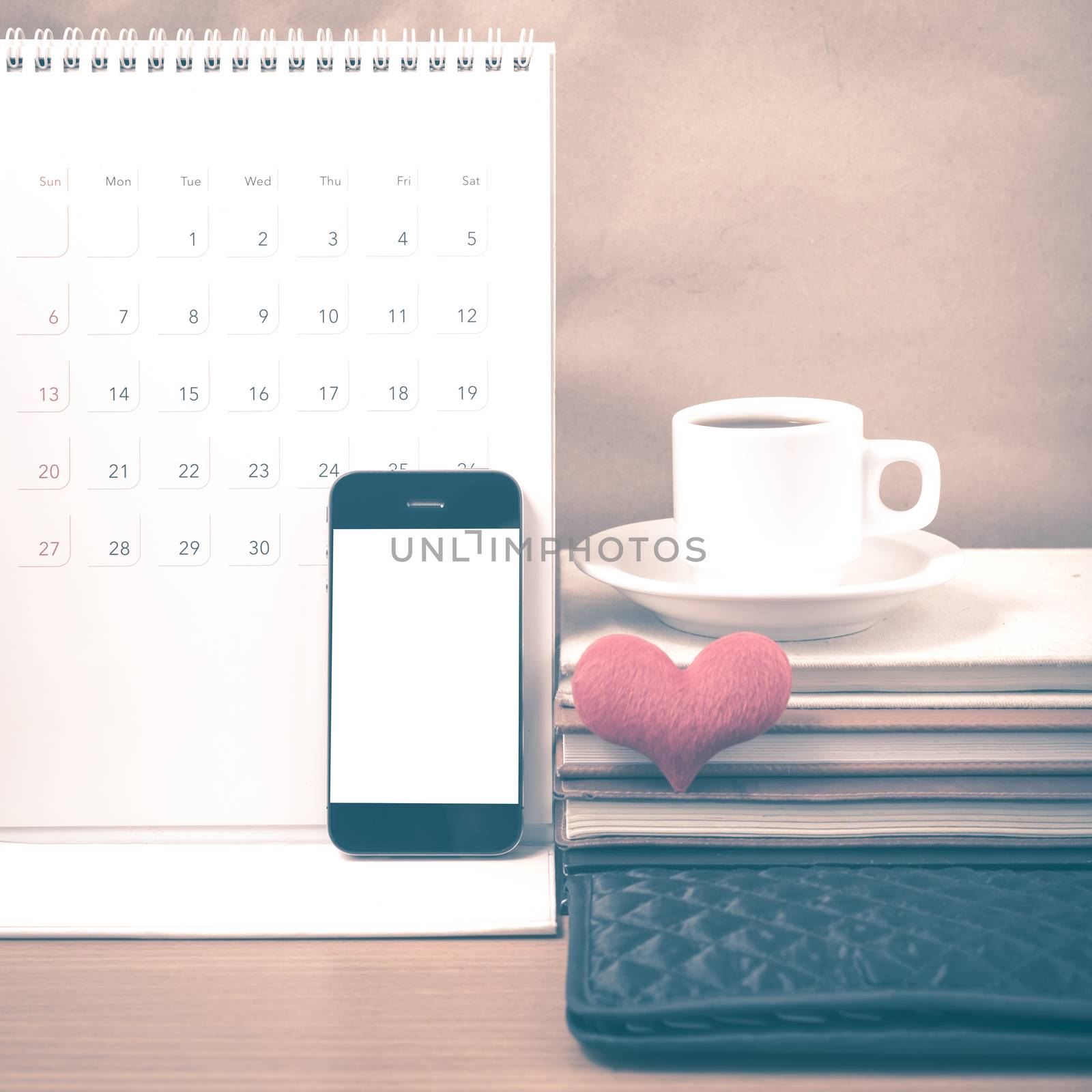 office desk : coffee with phone,wallet,calendar,heart,stack of book on wood background vintage style