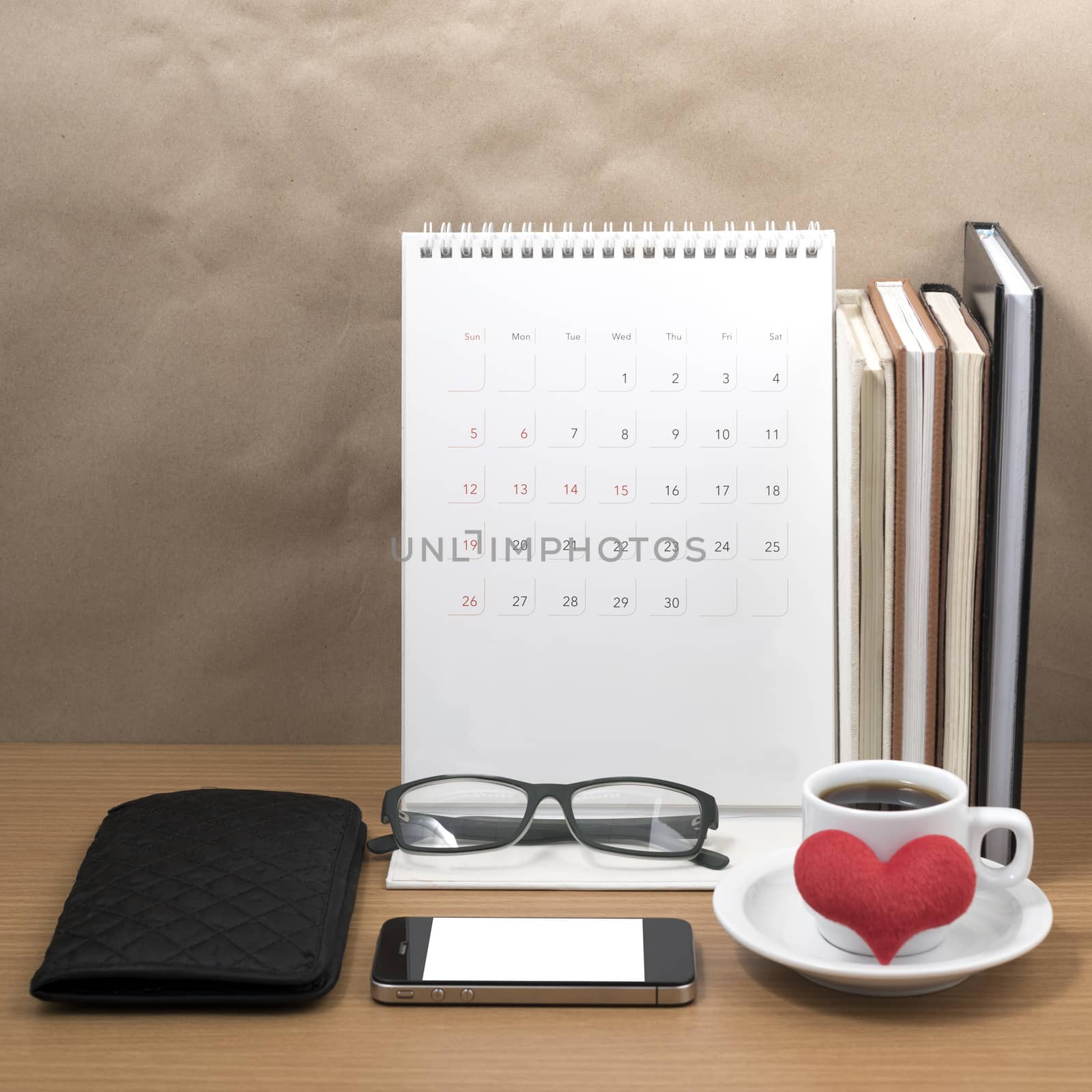 desktop : coffee with phone,stack of book,wallet,heart,eyeglasses,calendar on wood background