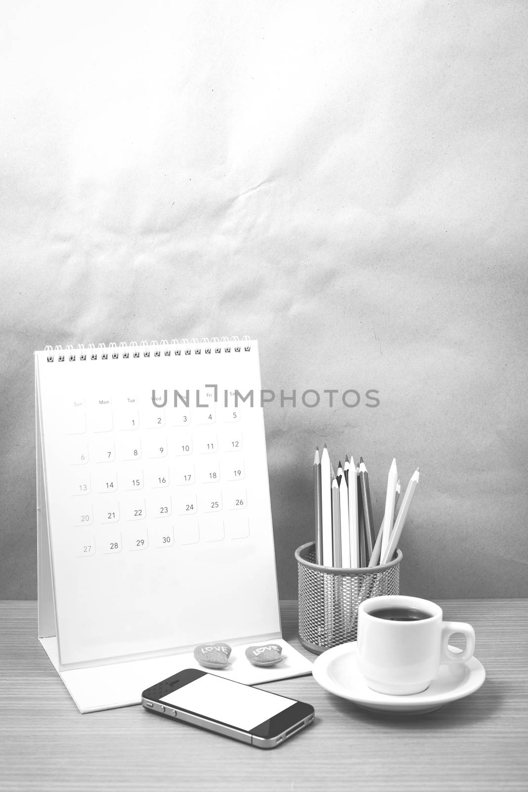 office desk : coffee with phone,calendar,heart,color pencil on wood background black and white color