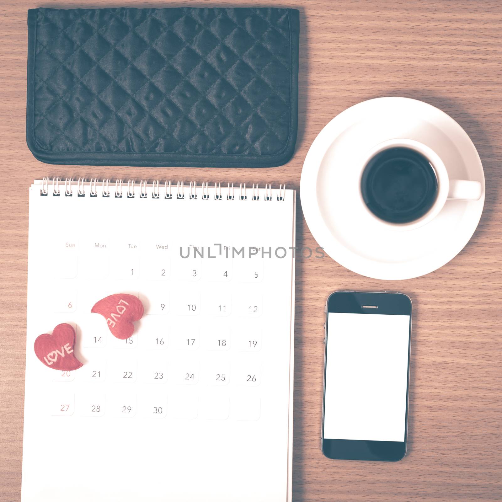 office desk : coffee with phone,calendar,wallet,heart on wood background vintage style
