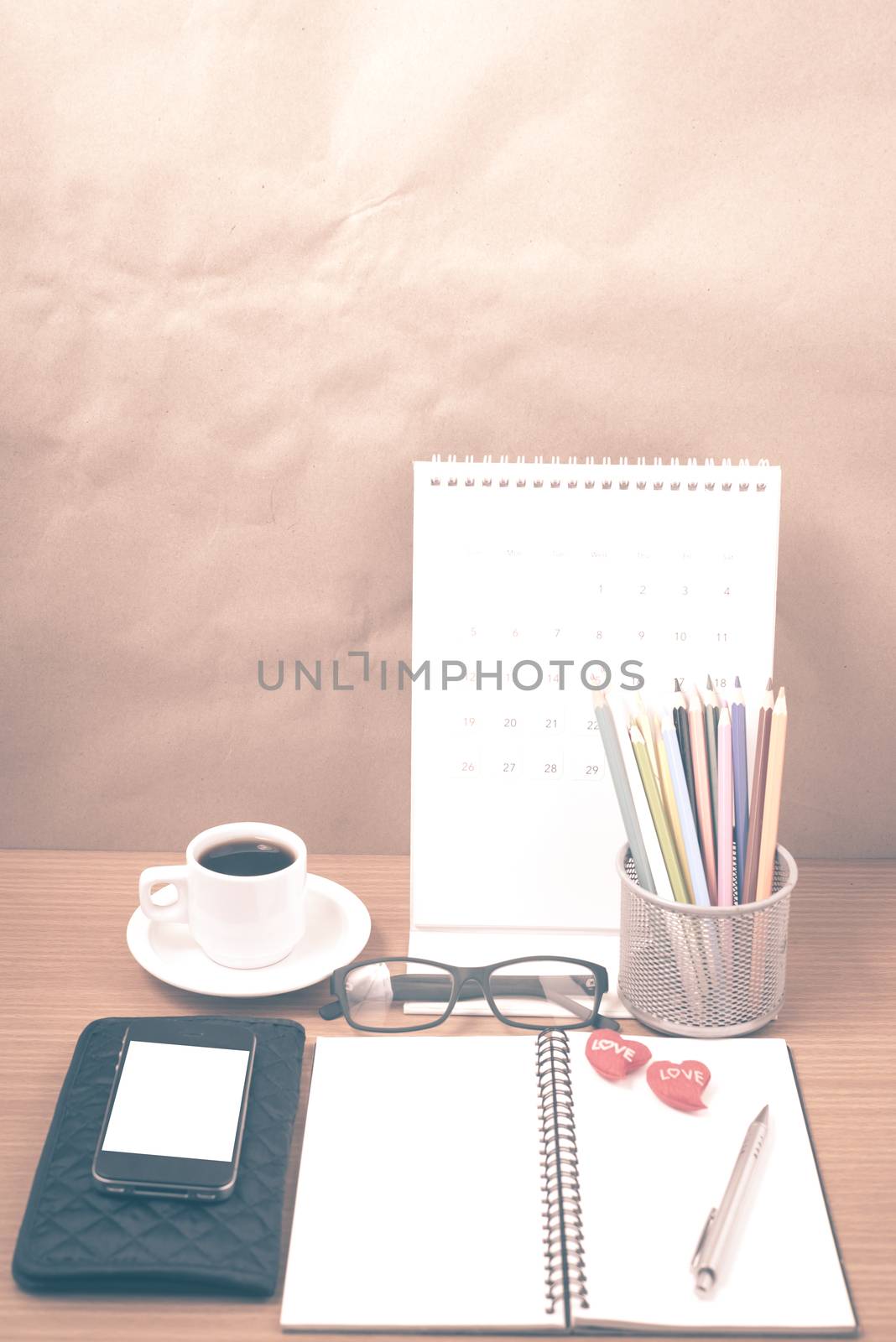 office desk : coffee with phone,wallet,calendar,color pencil box,notepad,heart on wood background vintage style