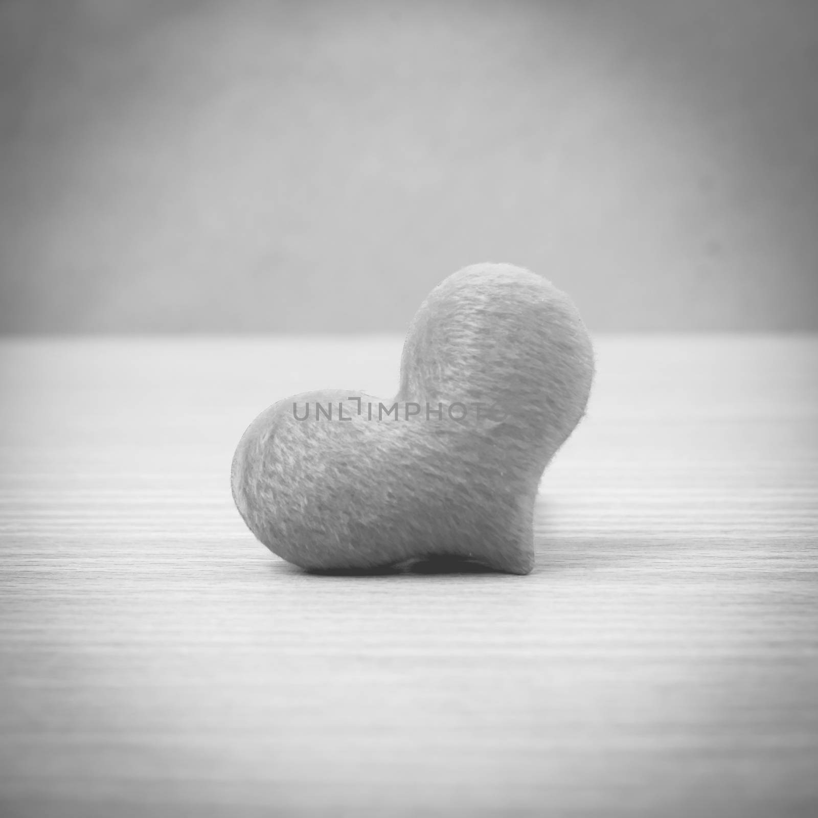 red heart on wood table background black and white color