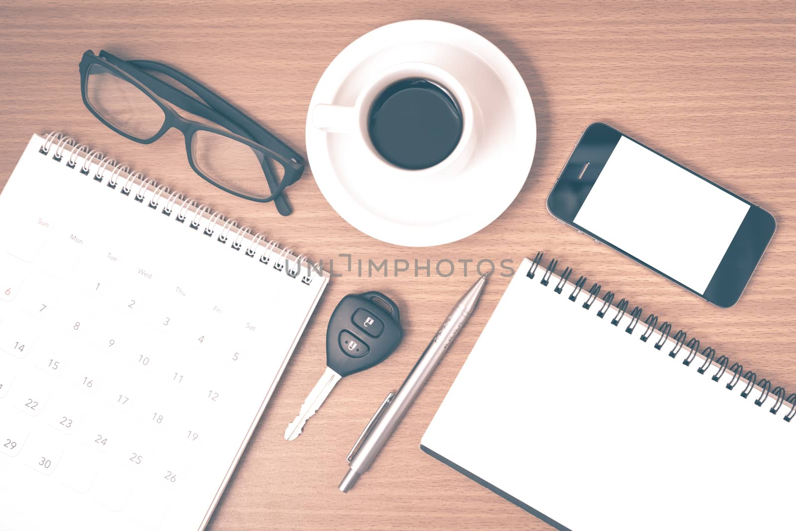 coffee and phone with car key,eyeglasses,notepad,calendar on wood background vintage style