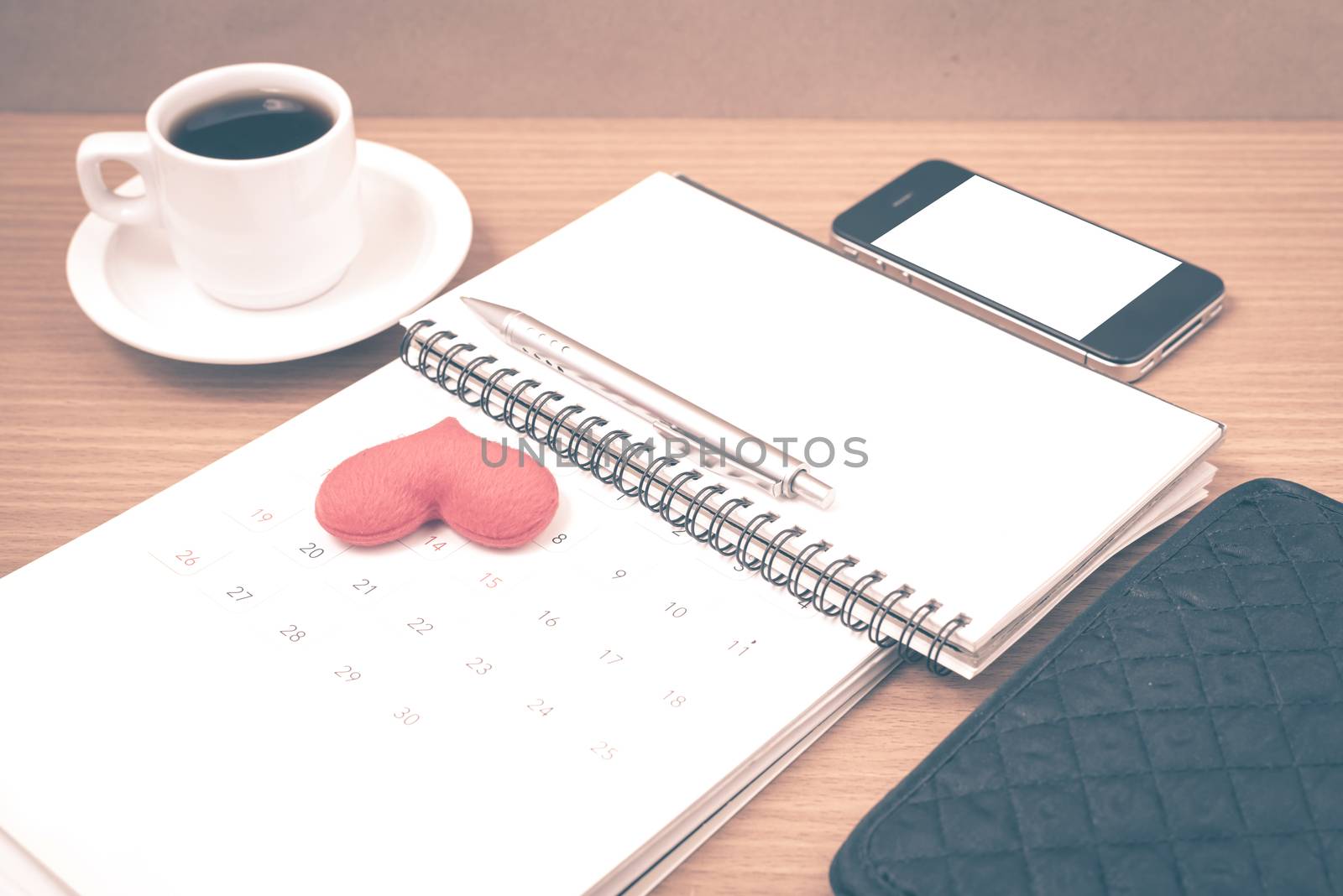 office desk : coffee with phone,wallet,calendar,heart,notepad on wood background vintage style