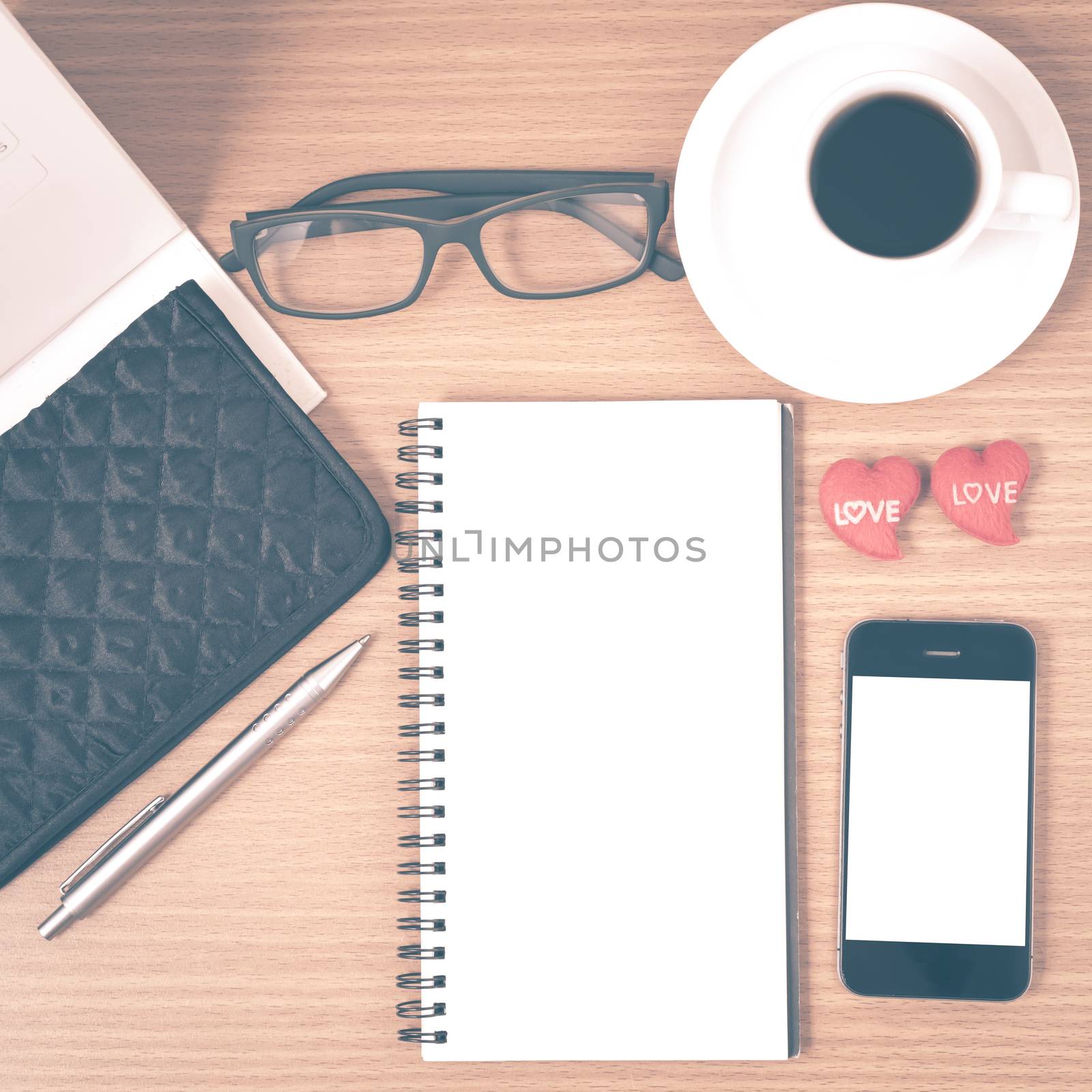 office desk : coffee with phone,wallet,calendar,heart,notepad,eyeglasses,heart on wood background vintage style