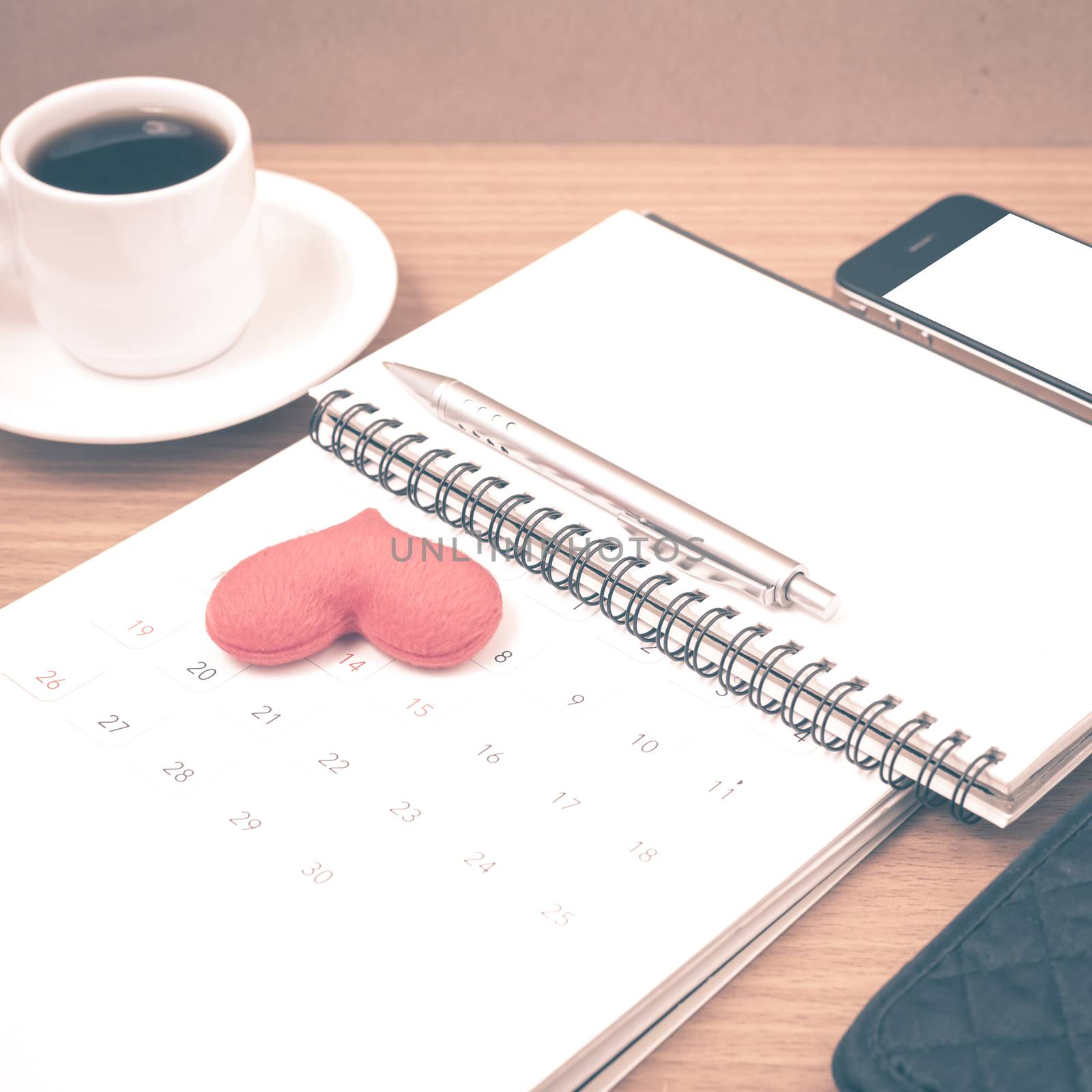 office desk : coffee with phone,wallet,calendar,heart,notepad on wood background vintage style