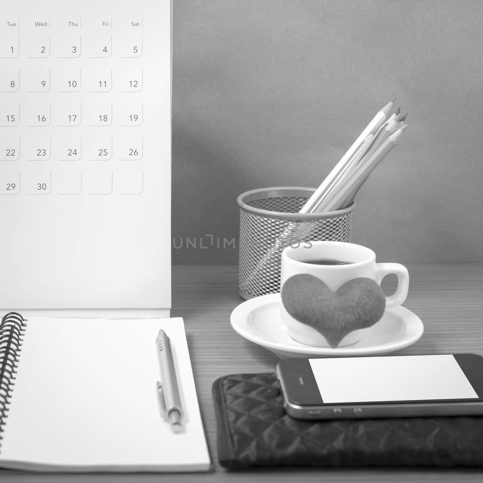 office desk : coffee with phone,wallet,calendar,heart,color pencil box,notepad,heart on wood background black and white color