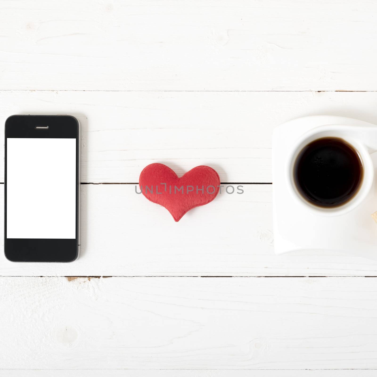 coffee cup with phone,heart on white wood background