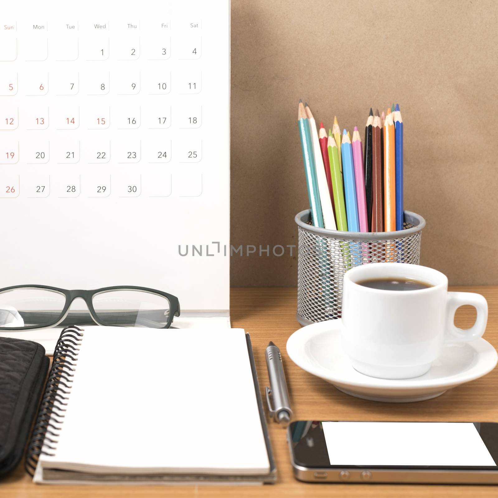 office desk : coffee with phone,wallet,calendar,heart,notepad,eyeglasses,color pencil box on wood background