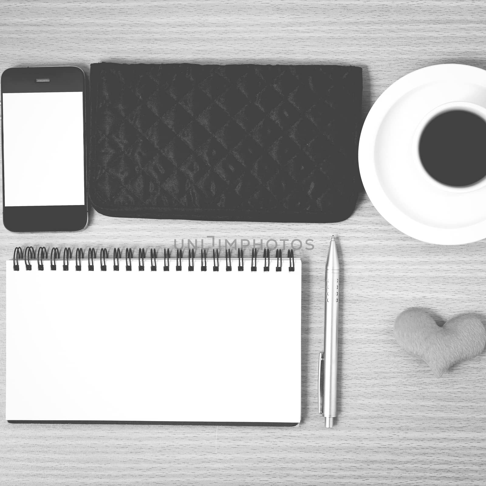 desktop : coffee with phone,notepad,wallet,heart on wood background black and white color