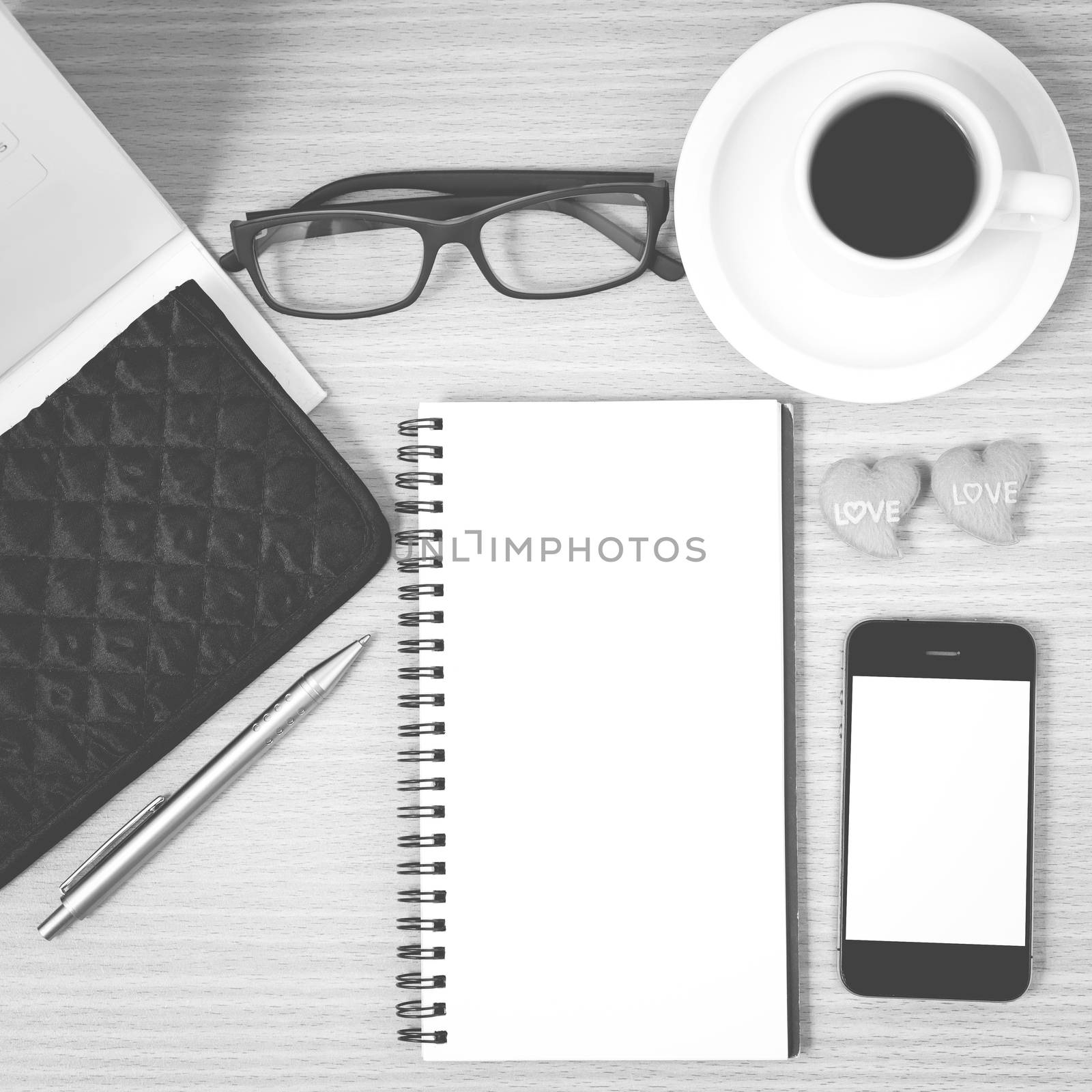 office desk : coffee with phone,wallet,calendar,heart,notepad,eyeglasses,heart on wood background black and white color