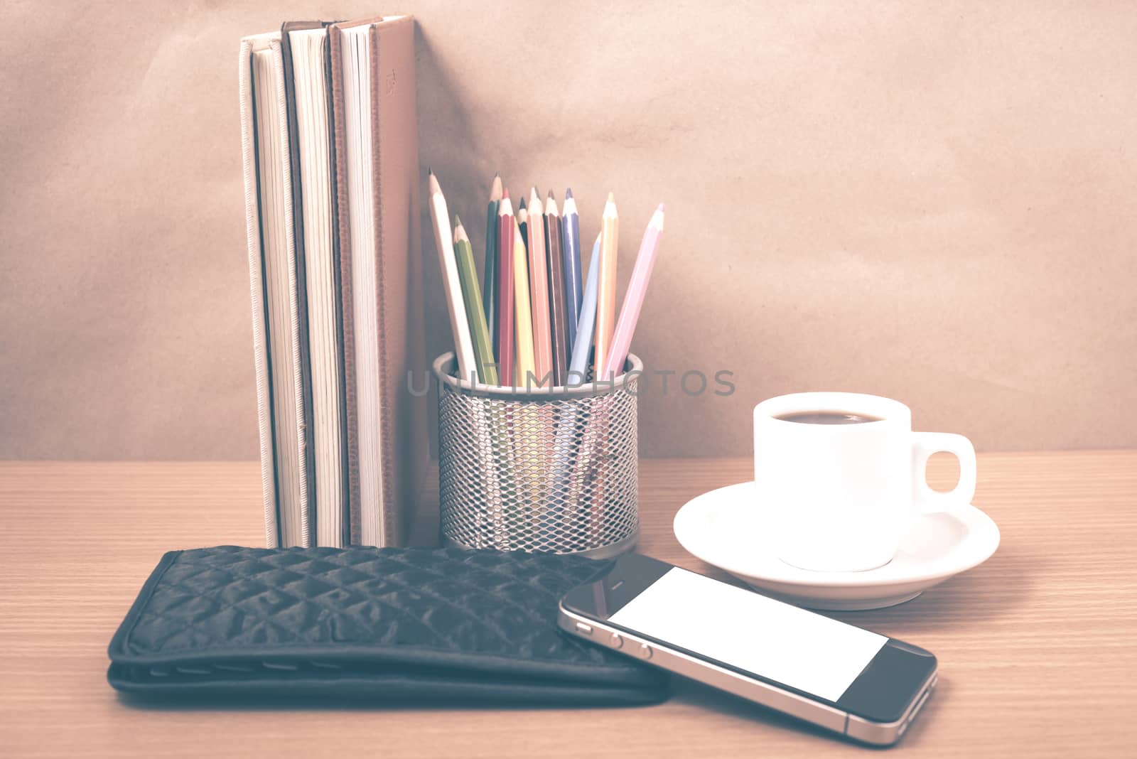 office desk : coffee with phone,stack of book,wallet,color box on wood background vintage style