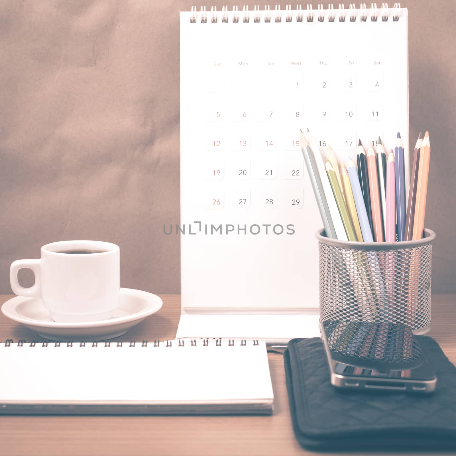 office desk : coffee with phone,wallet,calendar,color pencil box,notepad on wood background vintage style