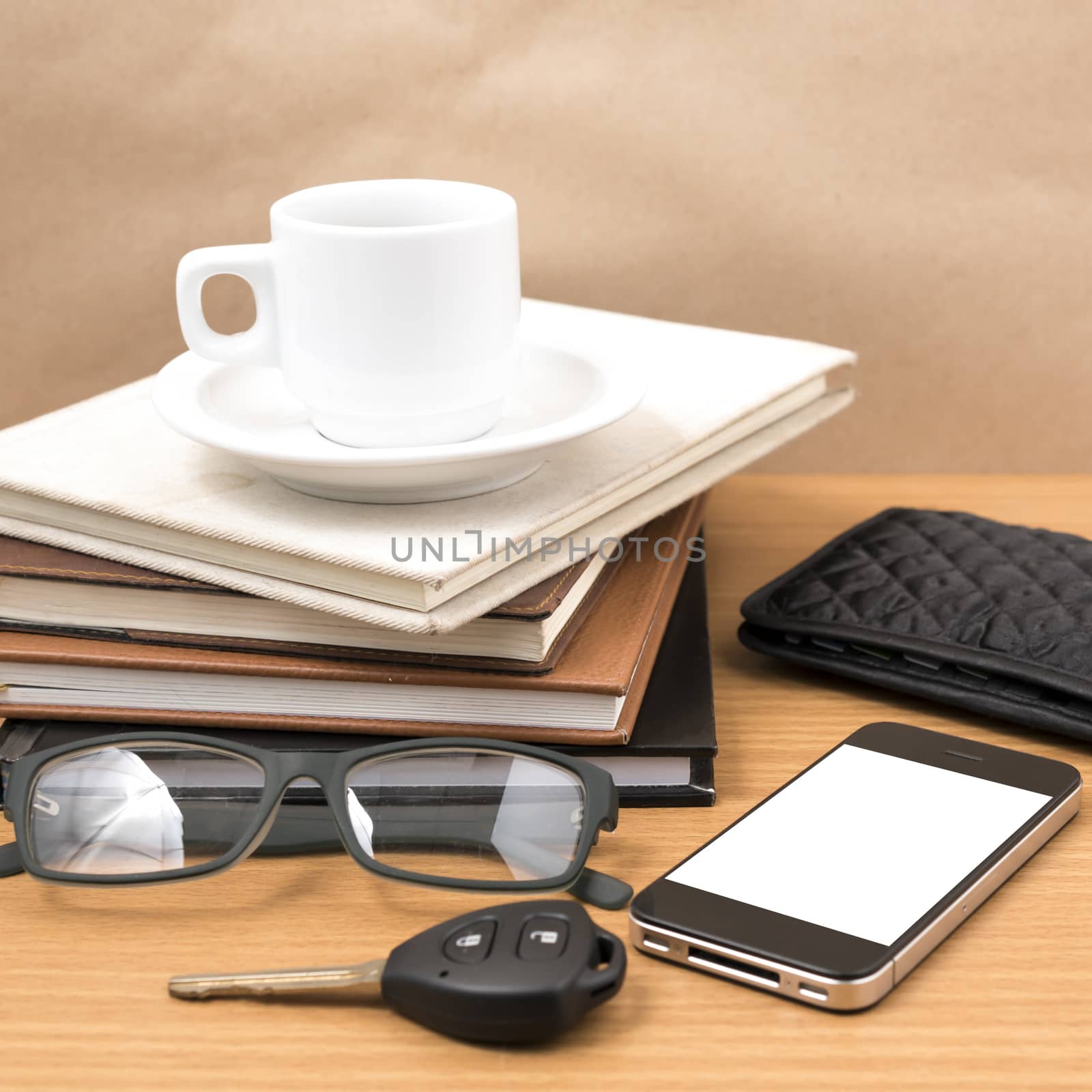 coffee and phone with stack of book,car key,eyeglasses and wallet on wood background