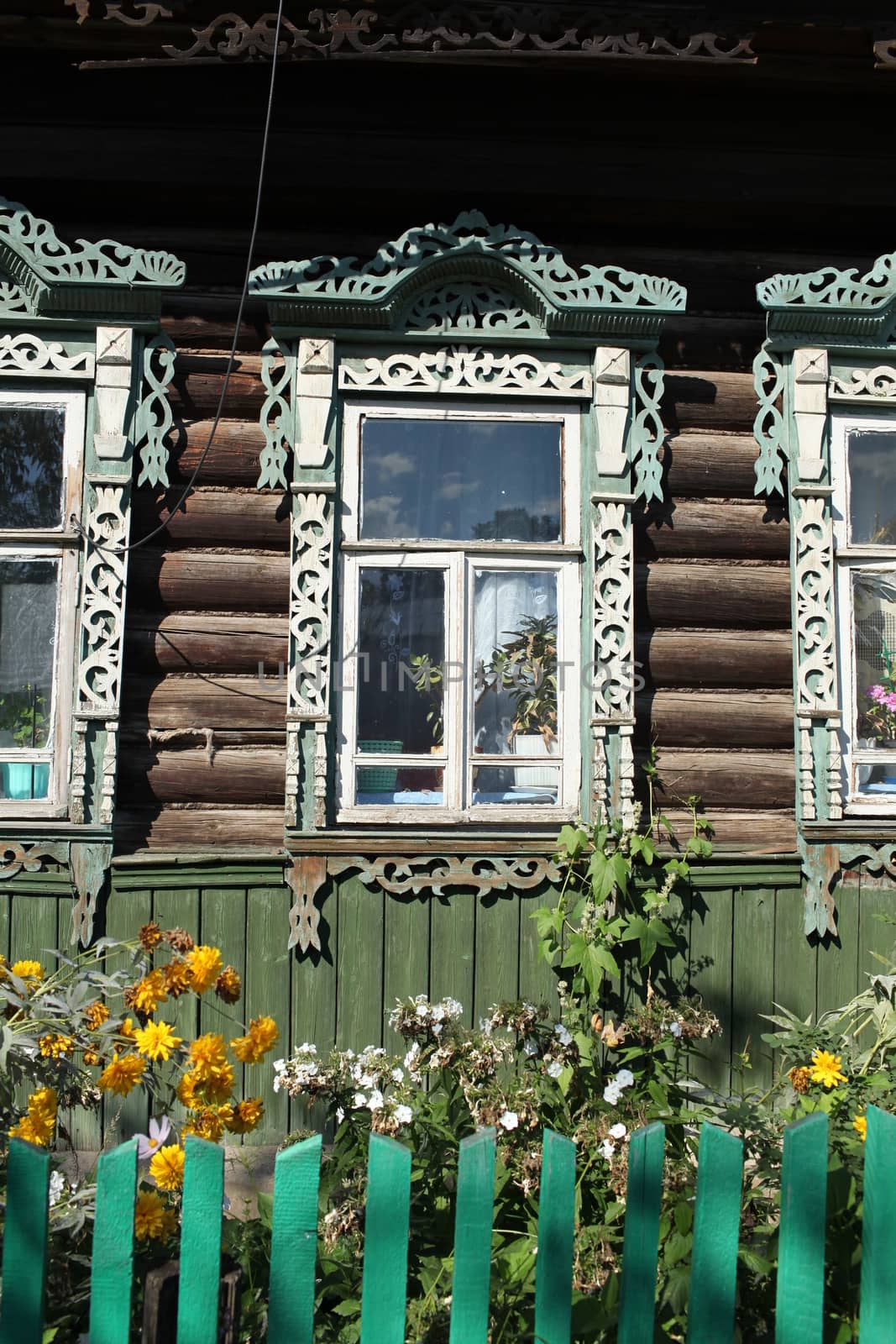 Window decorated with wood carvings on  log wall farmhouse