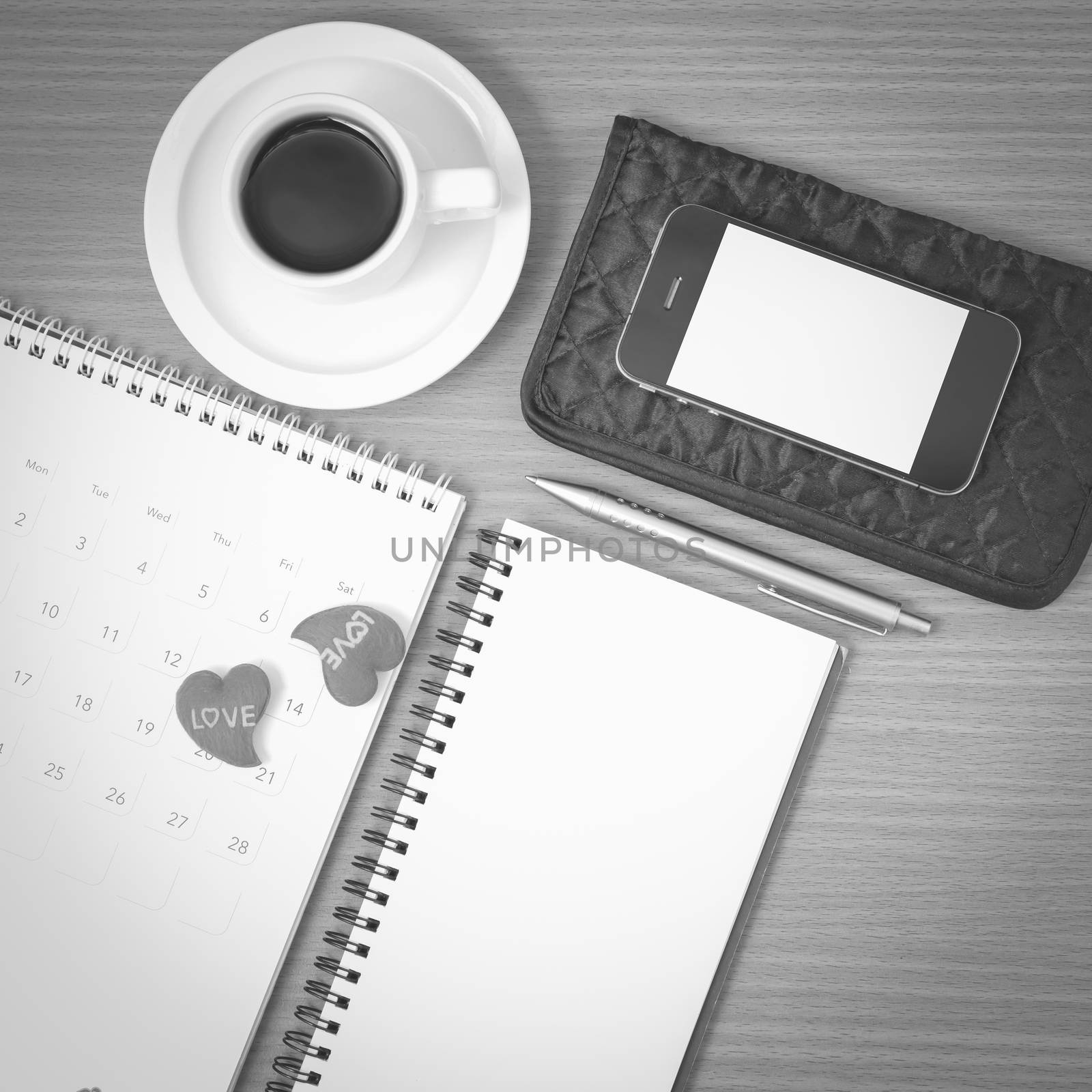 office desk : coffee with phone,wallet,calendar,heart,notepad on wood background black and white color