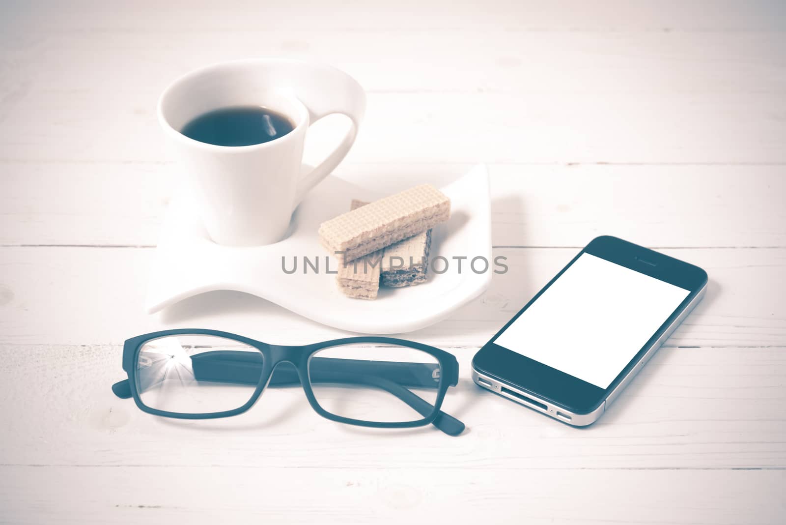 coffee cup with wafer,phone,eyeglasses on white wood background vintage style