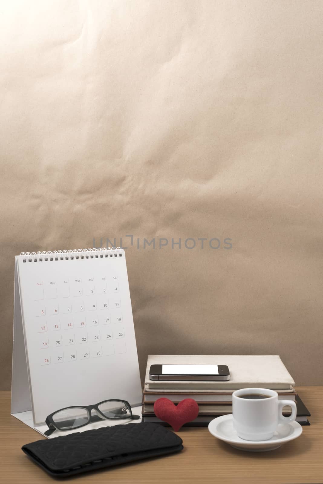 desktop : coffee with phone,stack of book,wallet,heart,eyeglasses,calendar on wood background