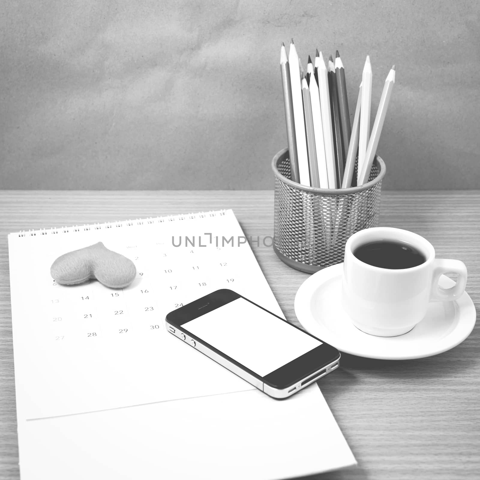 office desk : coffee with phone,calendar,heart on wood background black and white color