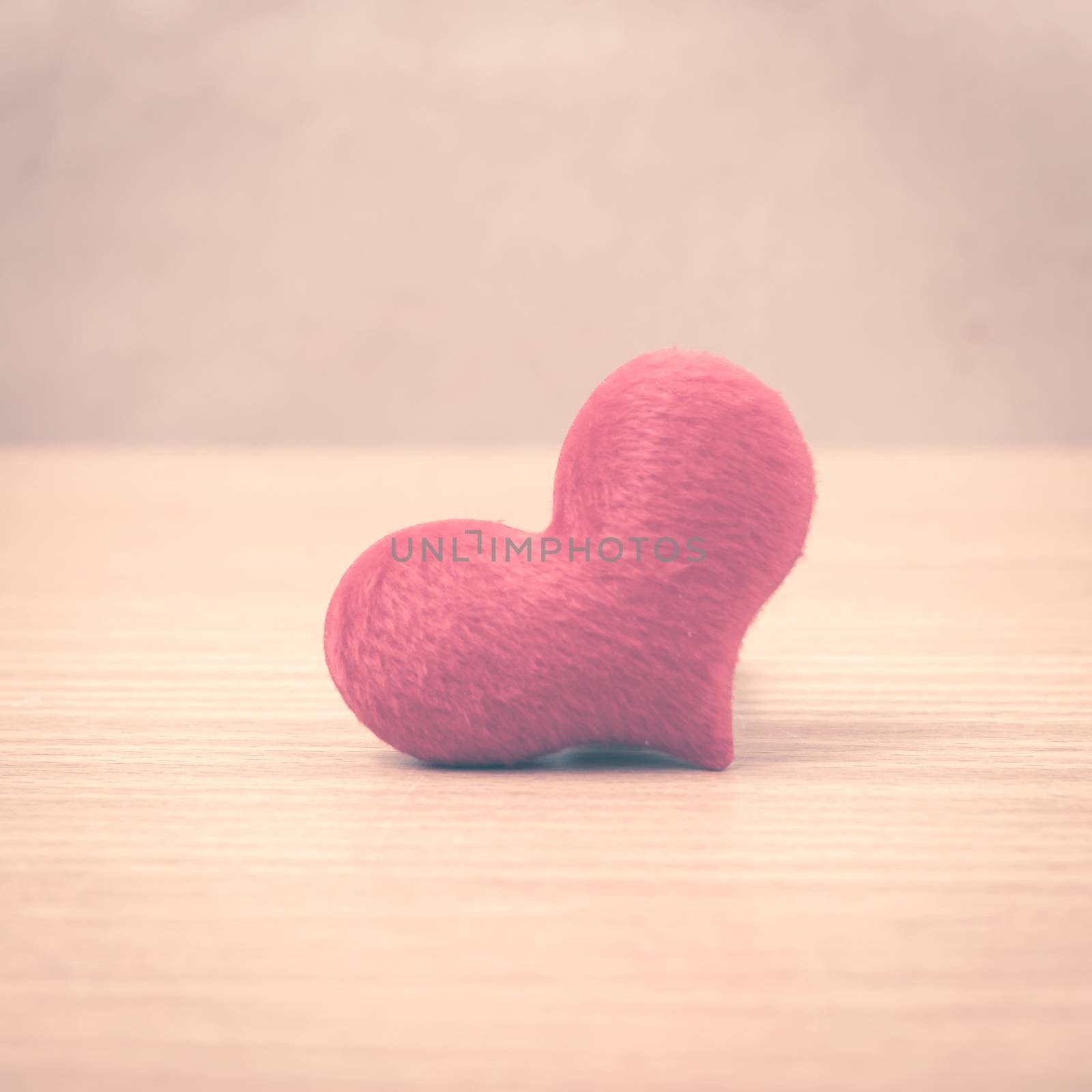 red heart on wood table background vintage style