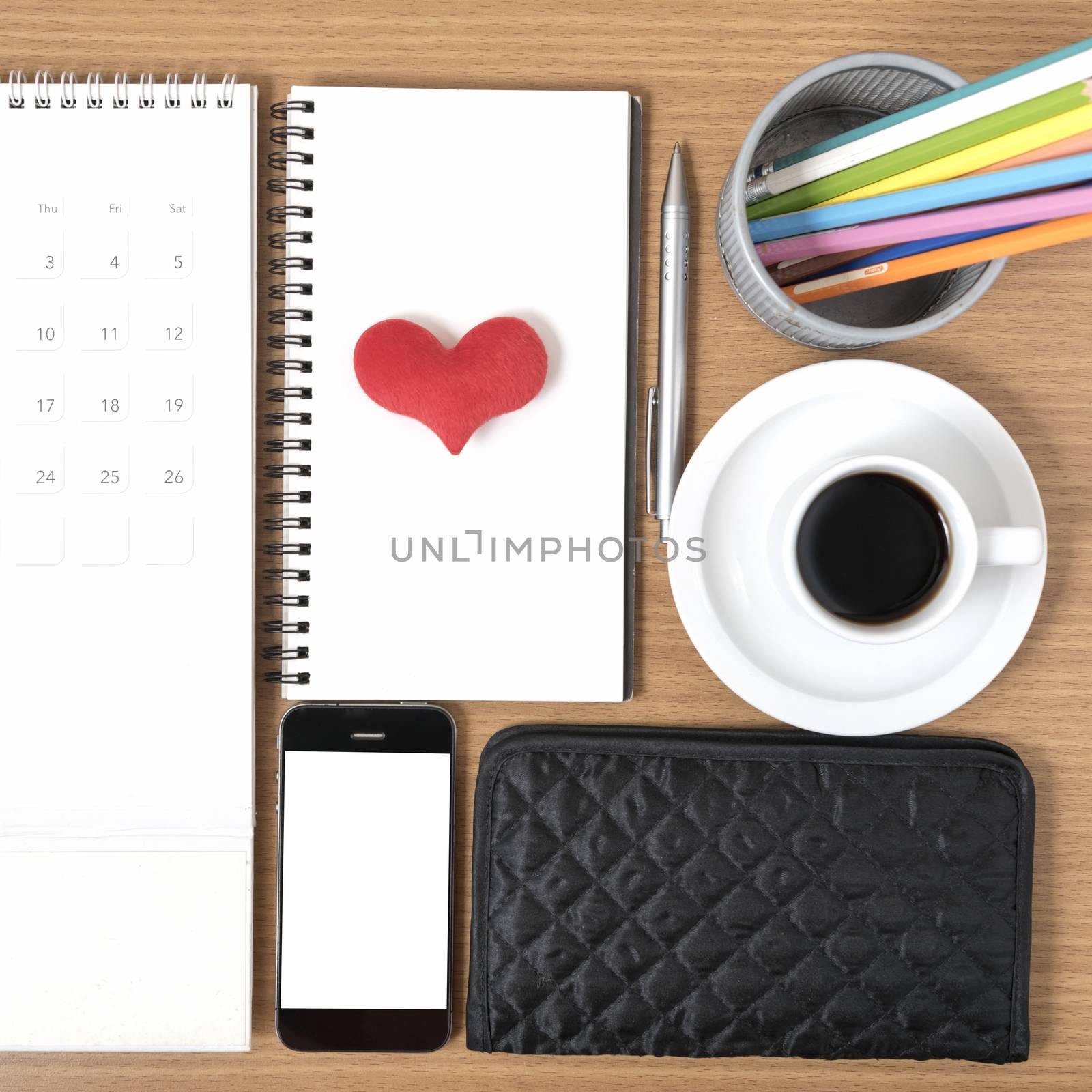 office desk : coffee with phone,wallet,calendar,heart,color pencil box,notepad,heart on wood background