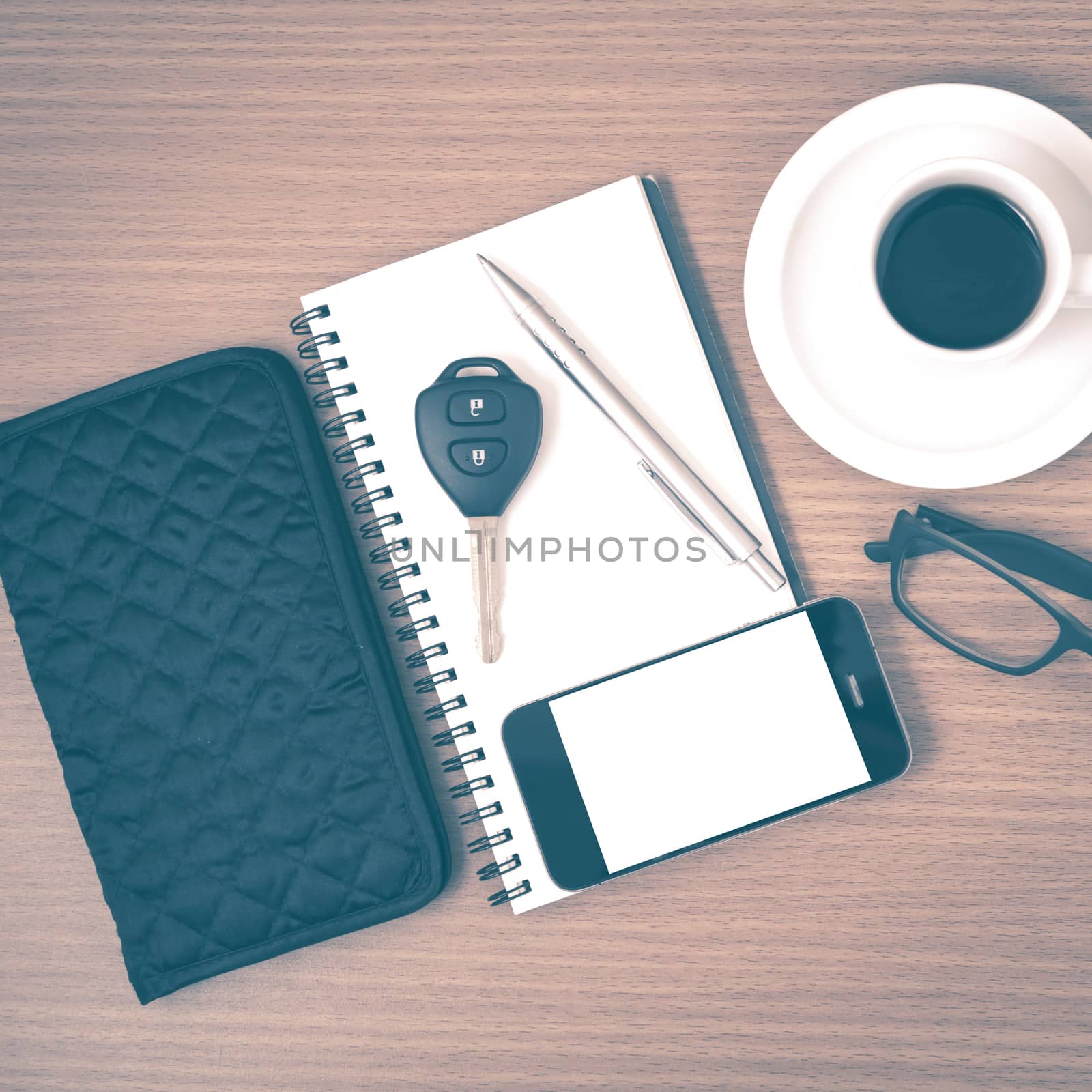 coffee and phone with notepad,car key,eyeglasses and wallet on wood table background vintage style