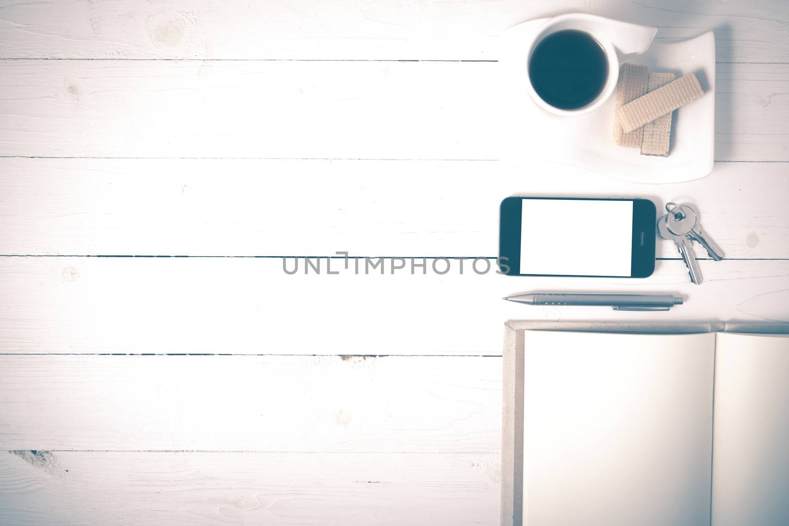 coffee cup with wafer,phone,key,notebook on white wood background vintage style