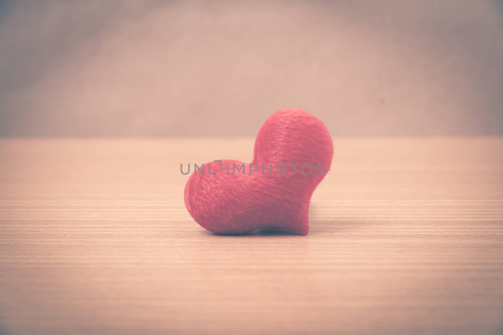 red heart on wood table background vintage style