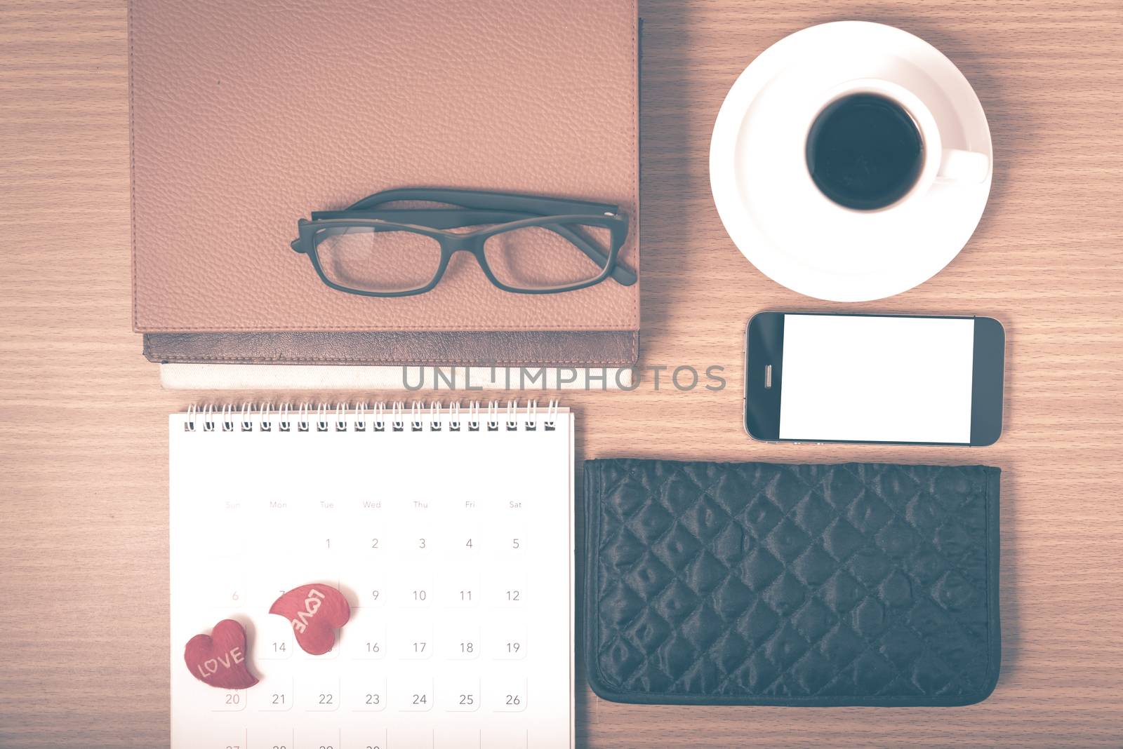 office desk : coffee with phone,stack of book,eyeglasses,wallet,calendar,heart on wood background vintage style