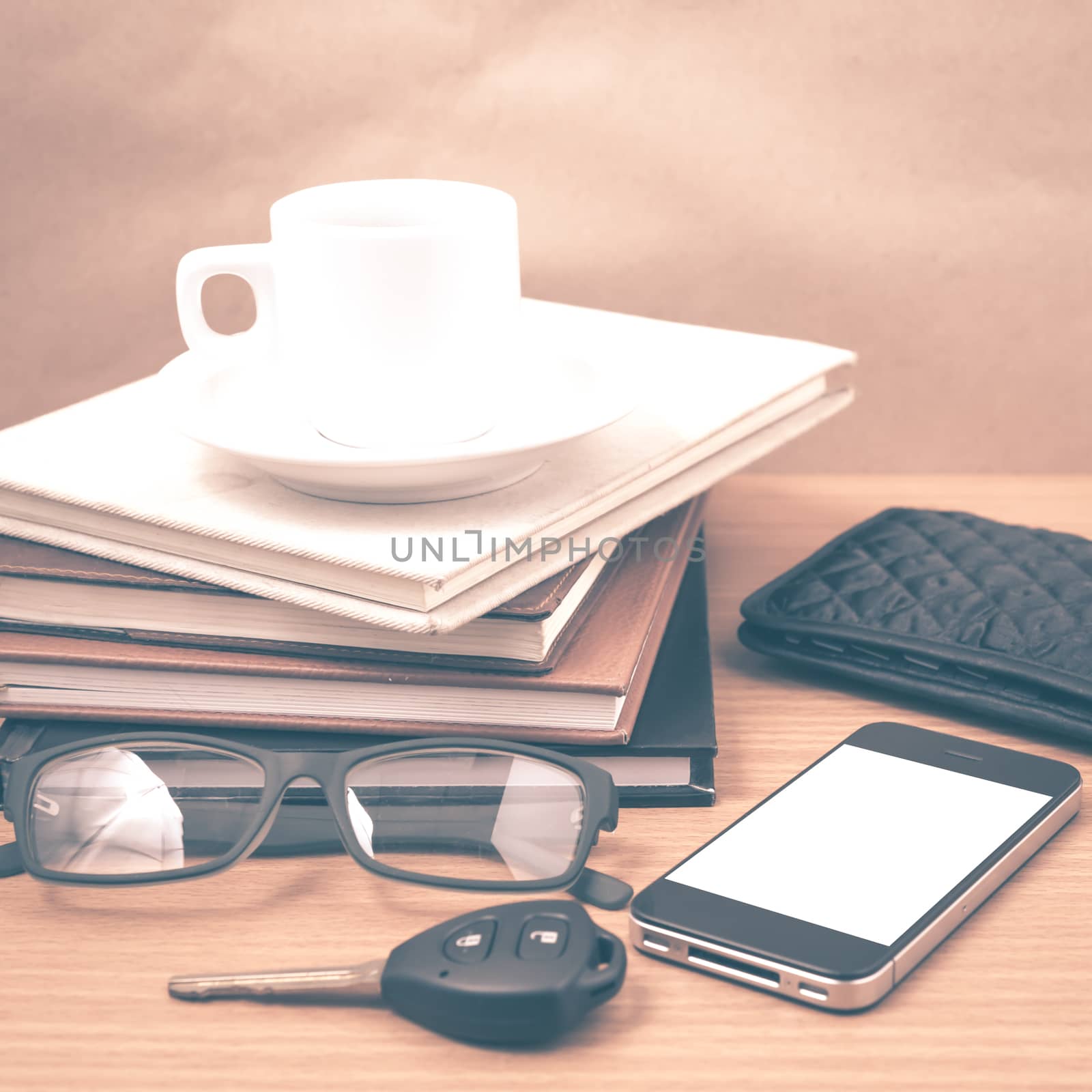 coffee and phone with stack of book,car key,eyeglasses and wallet on wood background vintage style