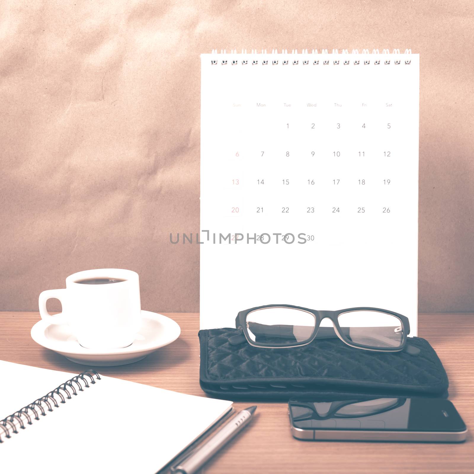 office desk : coffee with phone,calendar,wallet,notepad on wood background vintage style