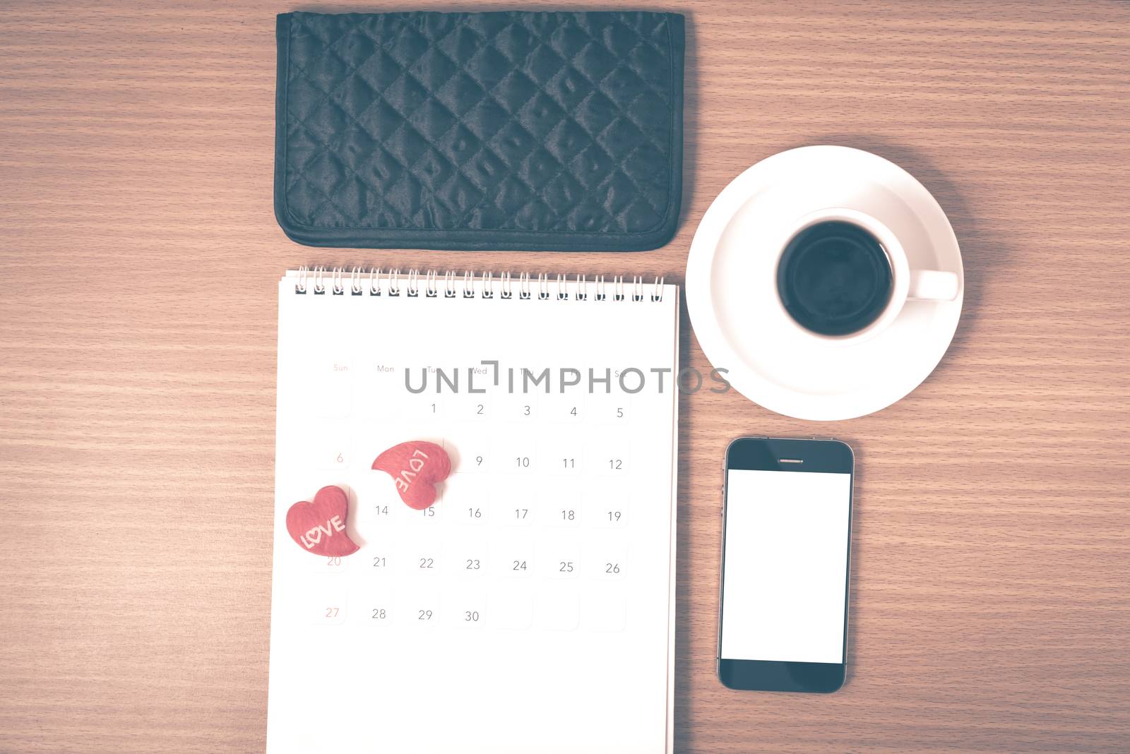 office desk : coffee with phone,calendar,wallet,heart on wood background vintage style