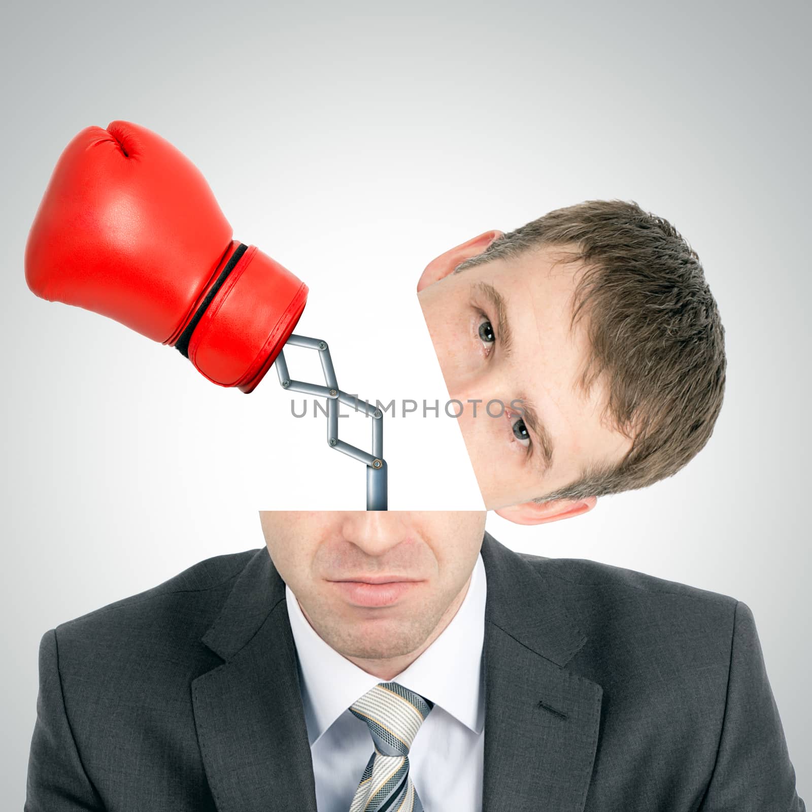 Boxing glove beating from businessmans head on grey background, front view