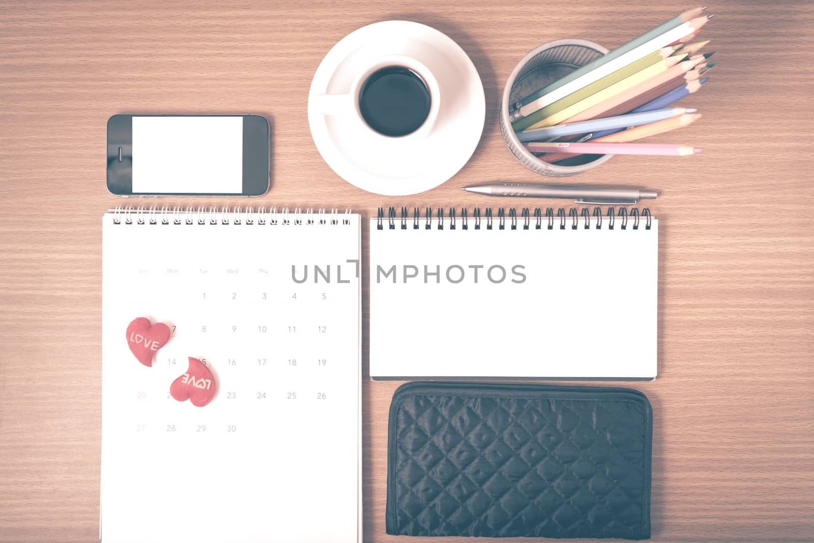 office desk : coffee with phone,wallet,calendar,heart,color pencil box,notepad on wood background vintage style