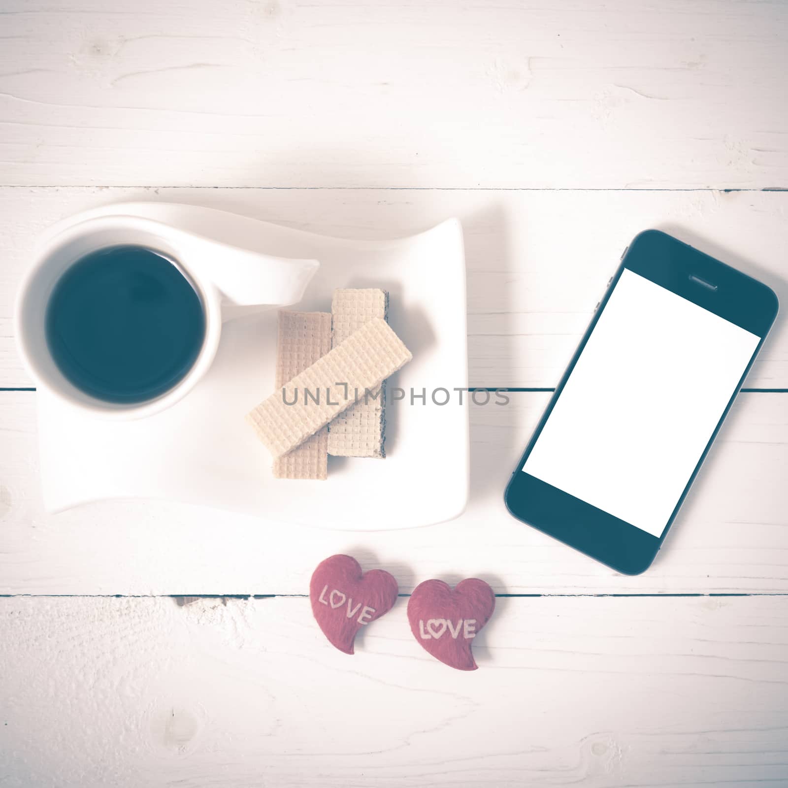 coffee cup with wafer,phone,heart on white wood background vintage style