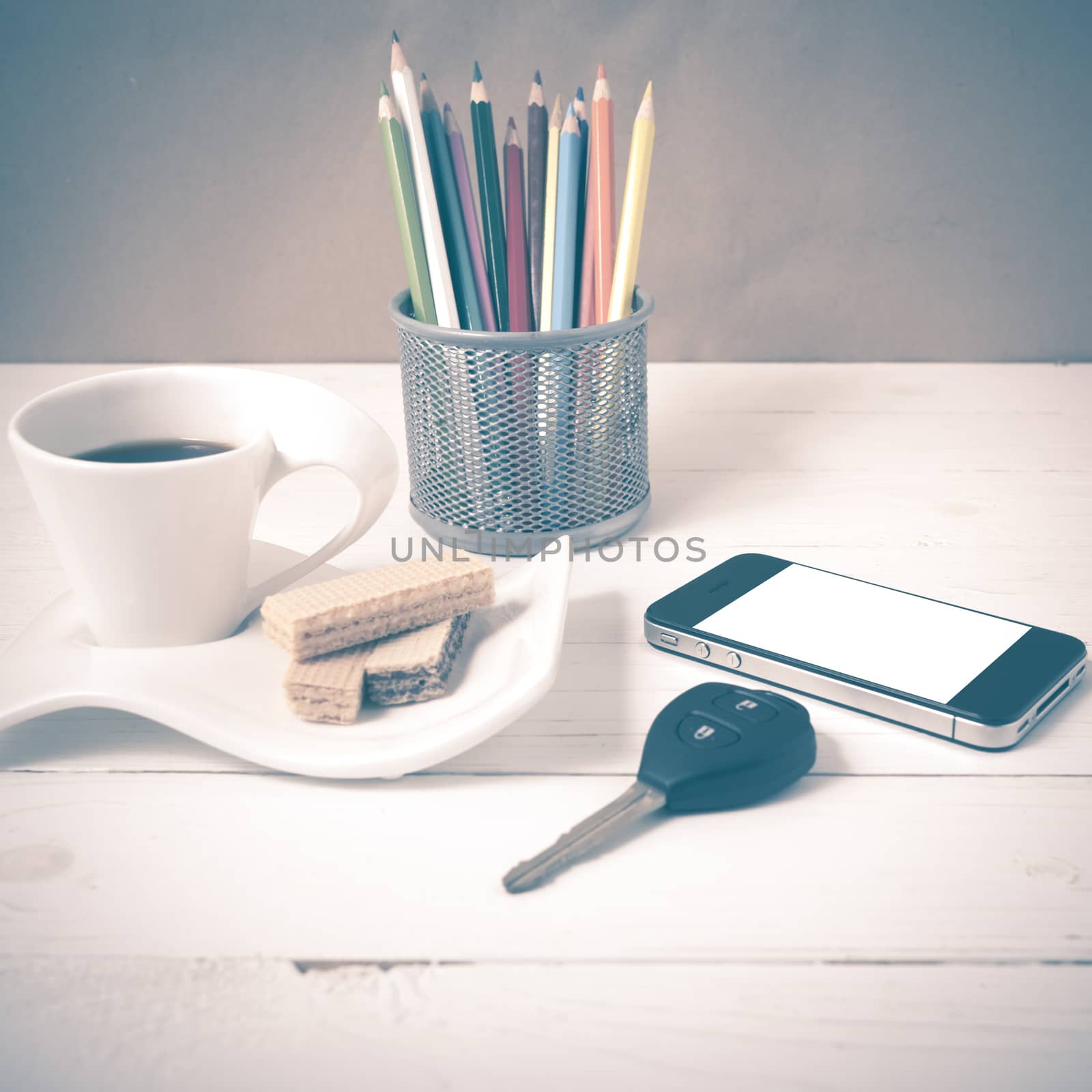 coffee cup with wafer,phone,pencil box,car key on white wood background vintage style