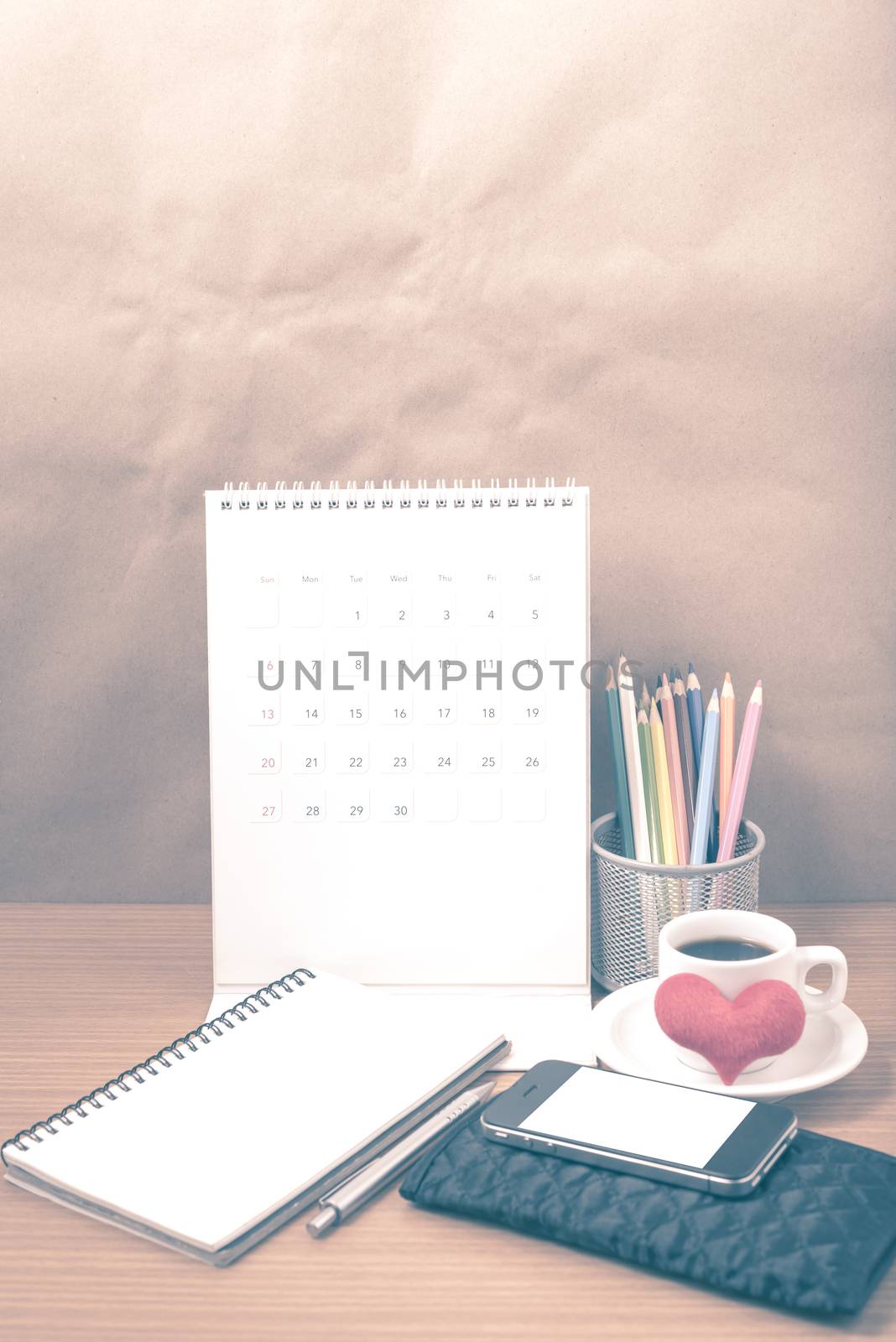 office desk : coffee with phone,wallet,calendar,heart,color pencil box,notepad,heart on wood background vintage style