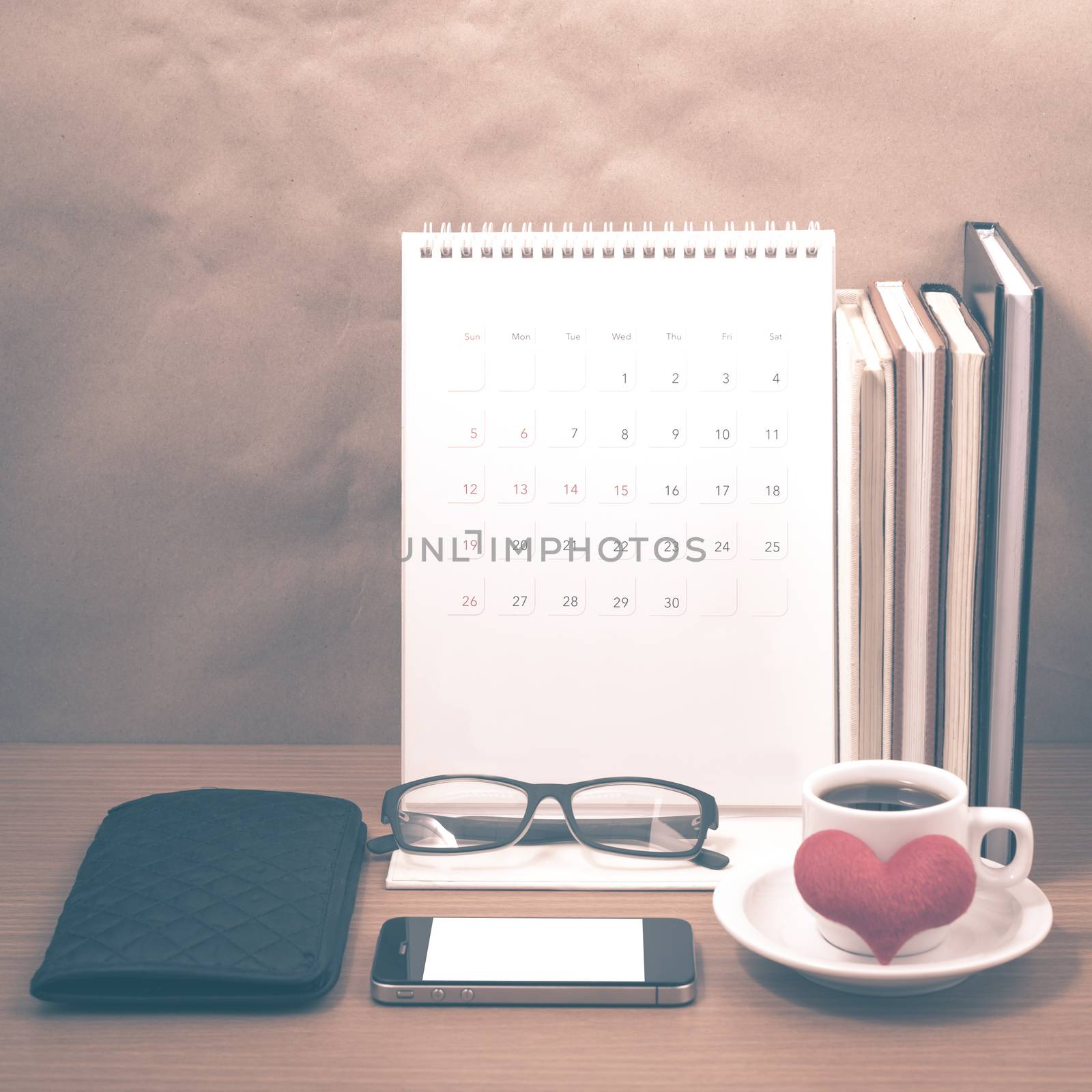 desktop : coffee with phone,stack of book,wallet,heart,eyeglasses,calendar on wood background vintage style